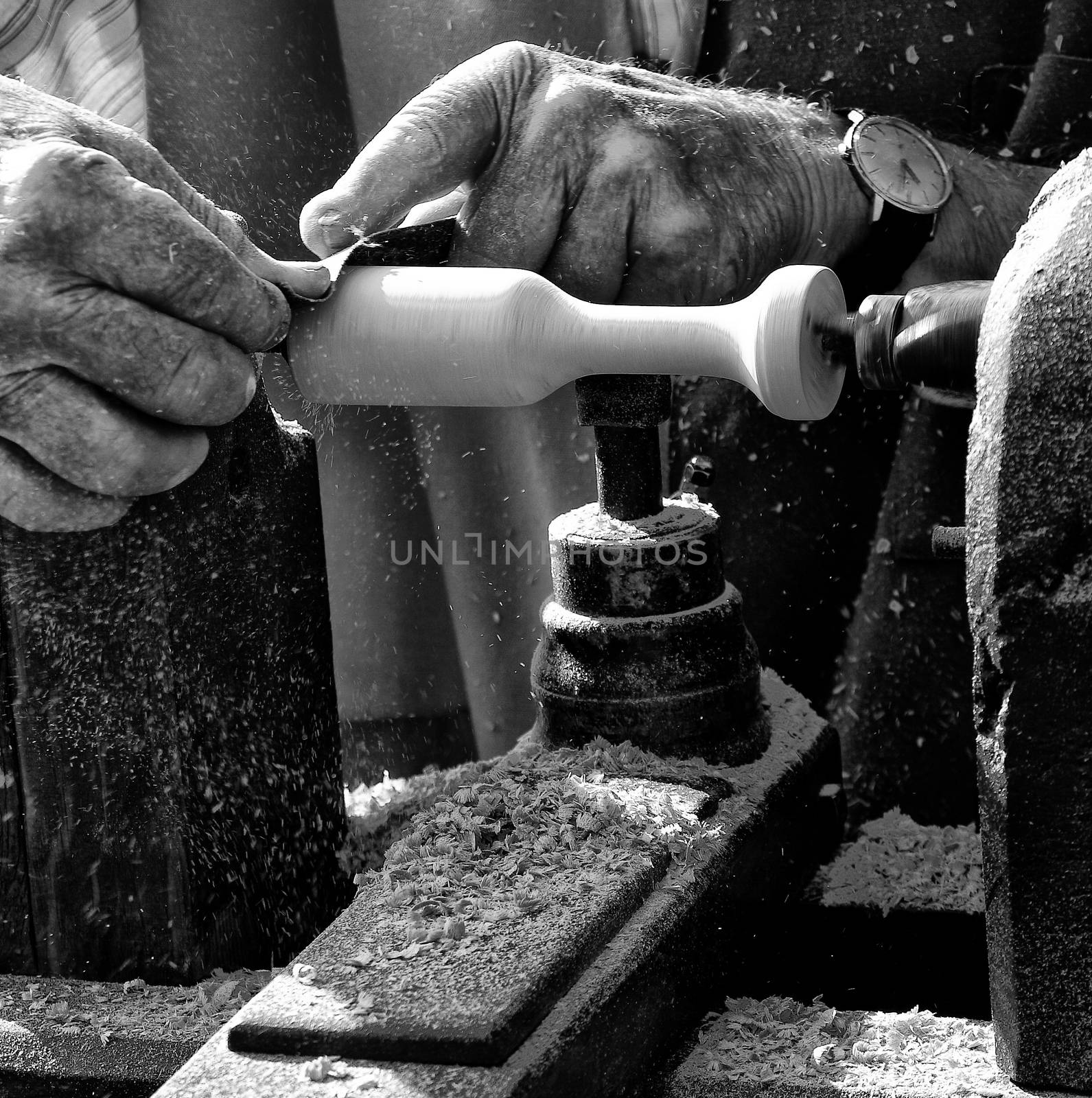 A man using a lathe to carve out a wood product