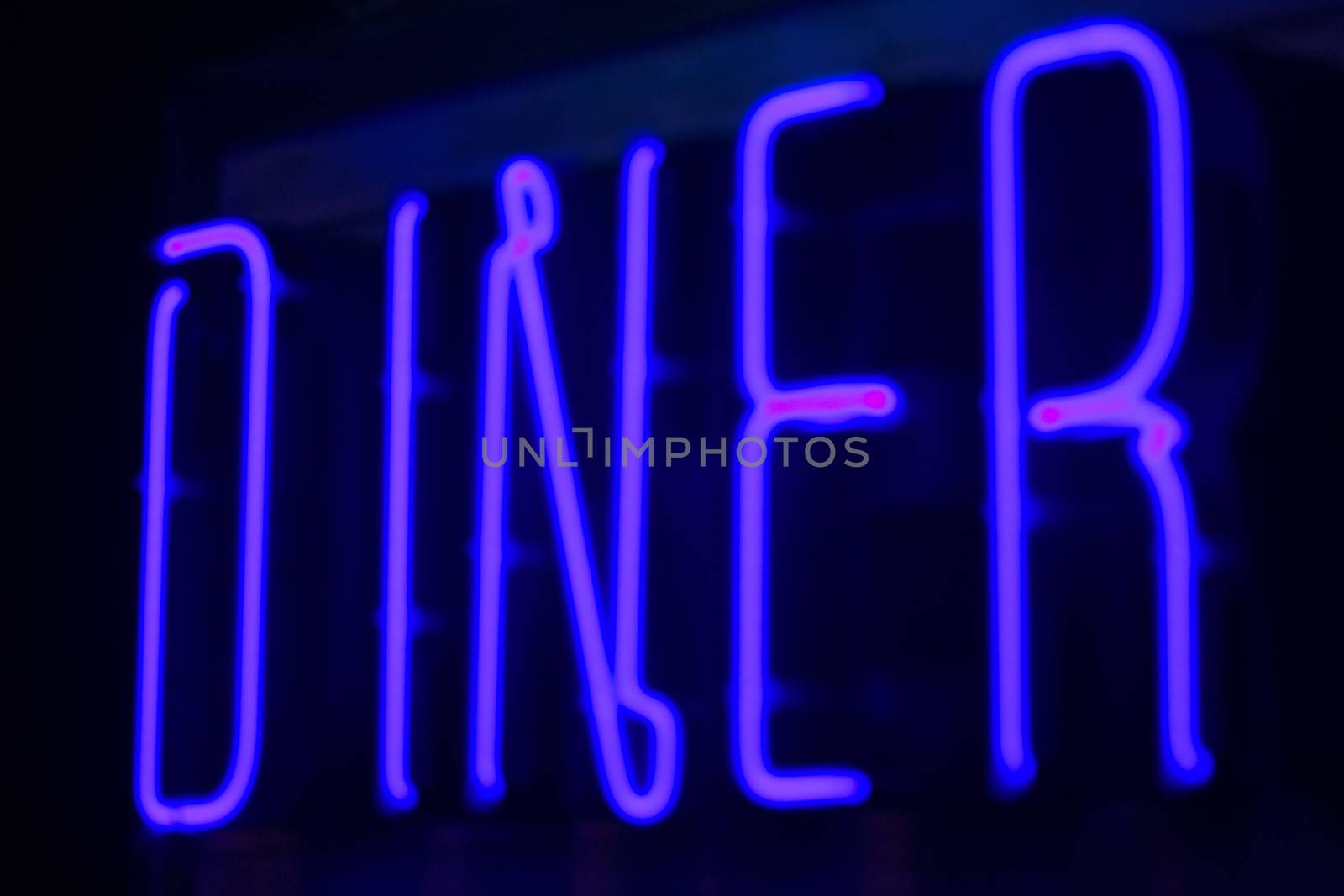 Diner neon sign at night in street photo.