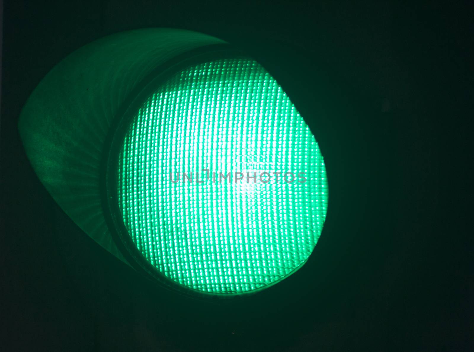 Traffic green go light photo at night on black background.