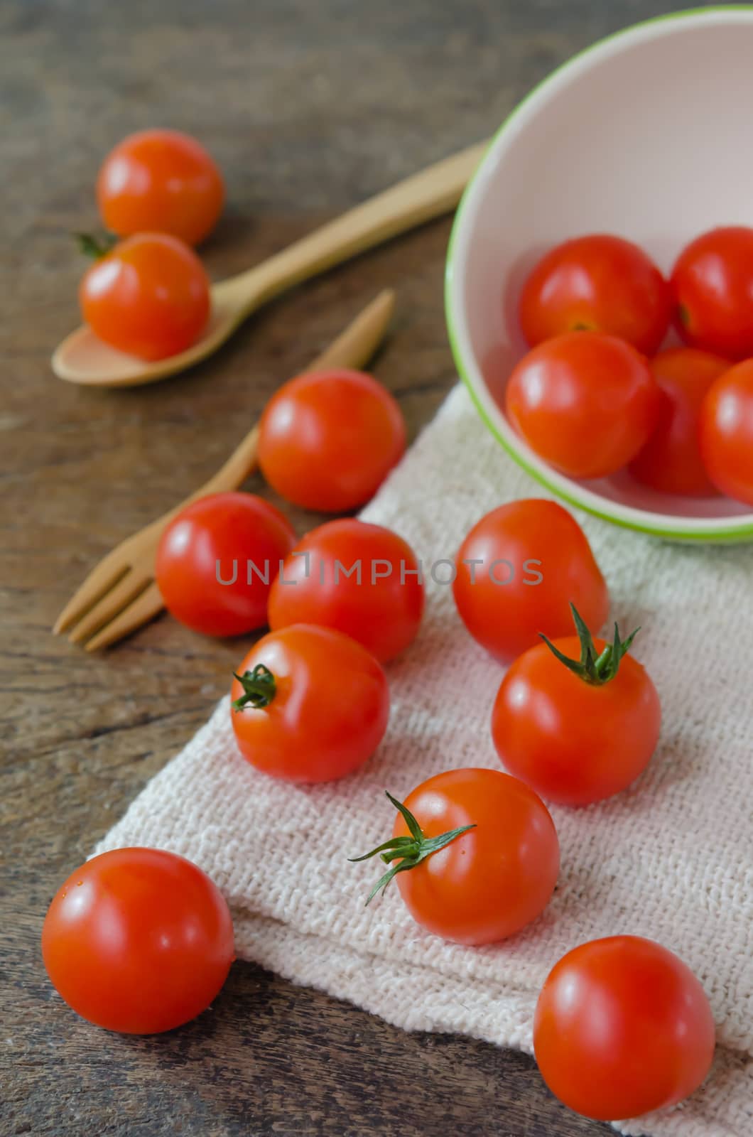 Red cherry tomatoes  on a textured  wooden background