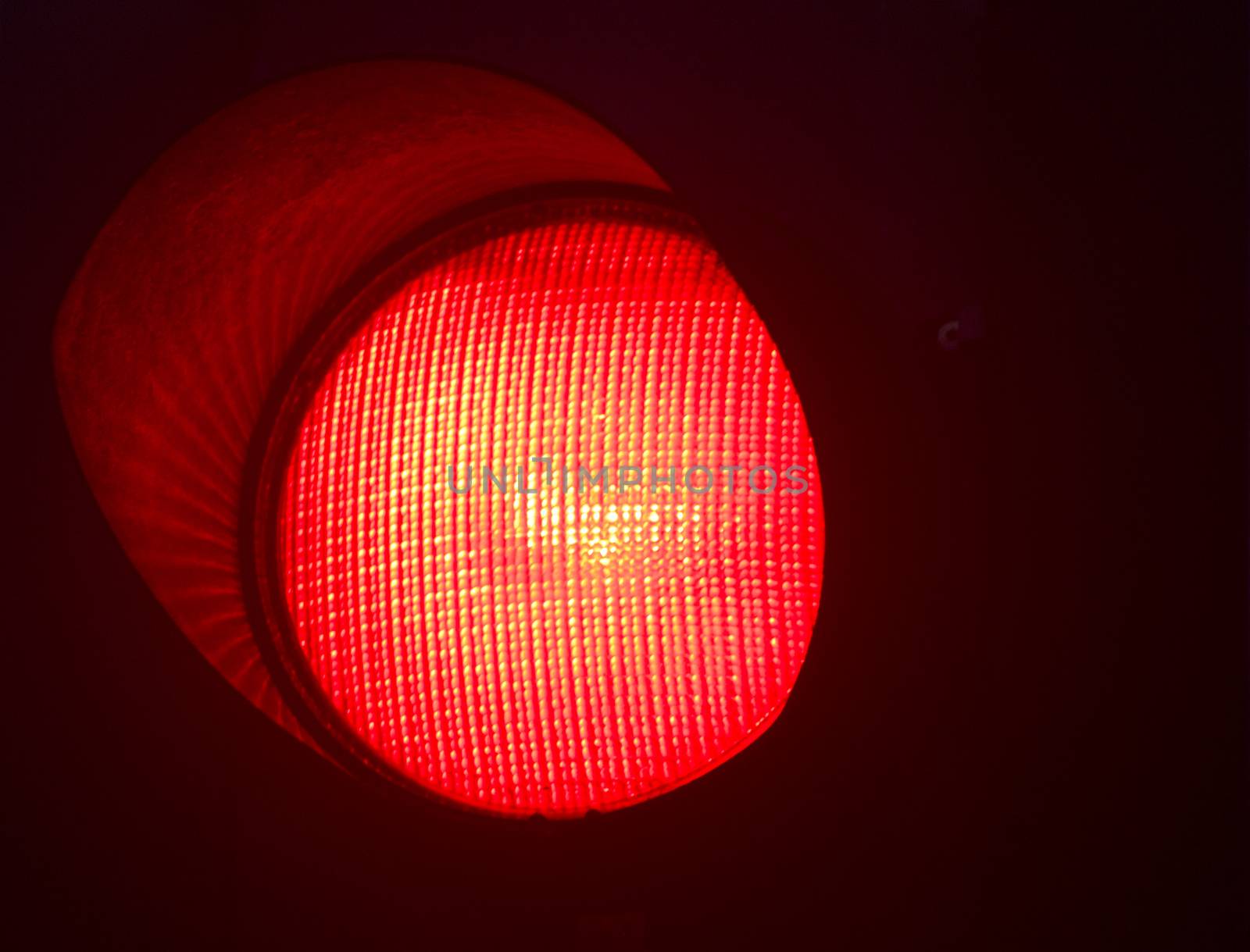 Traffic red stop light photo at night on black background.