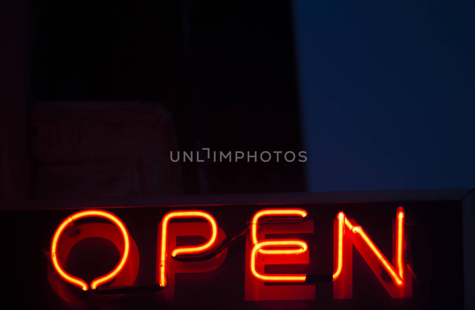 Neon open sign at night in street photo.