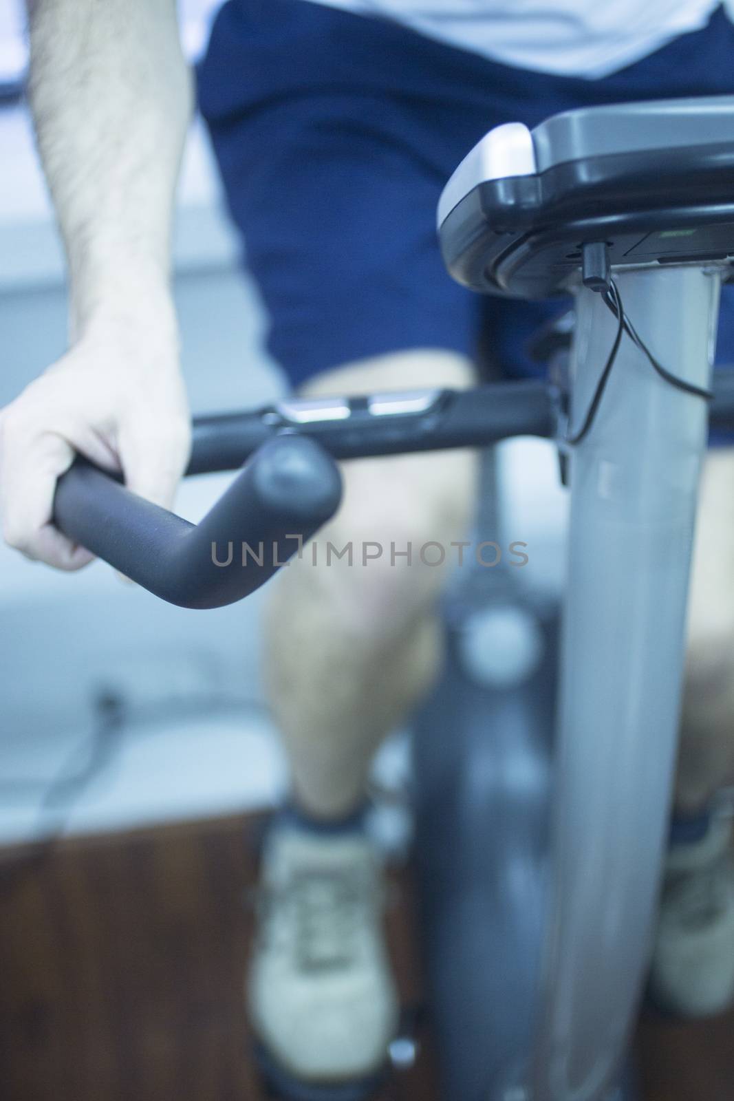 Young man on exercise bike by edwardolive