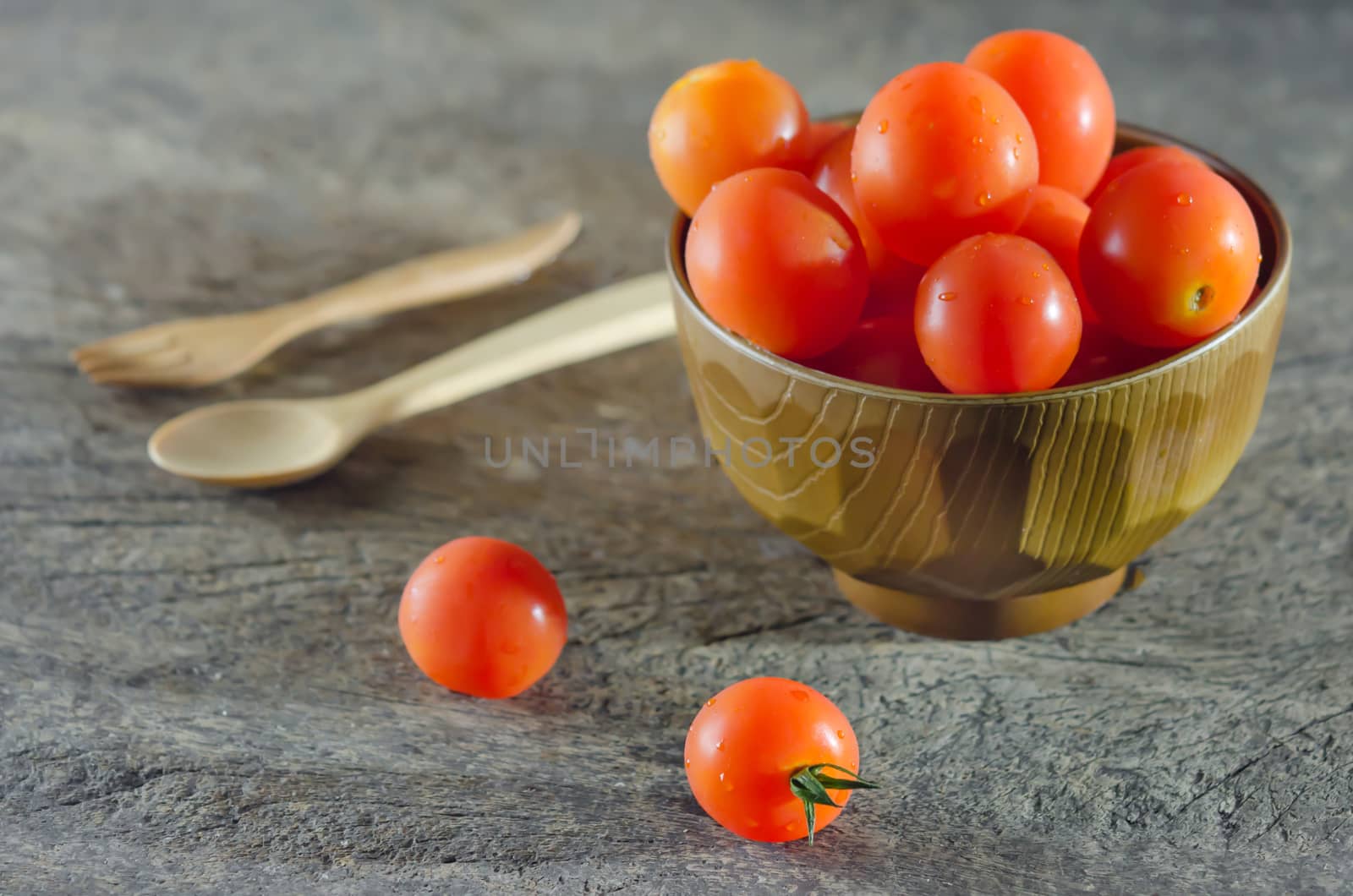 Red cherry tomatoes  on a textured  wooden background