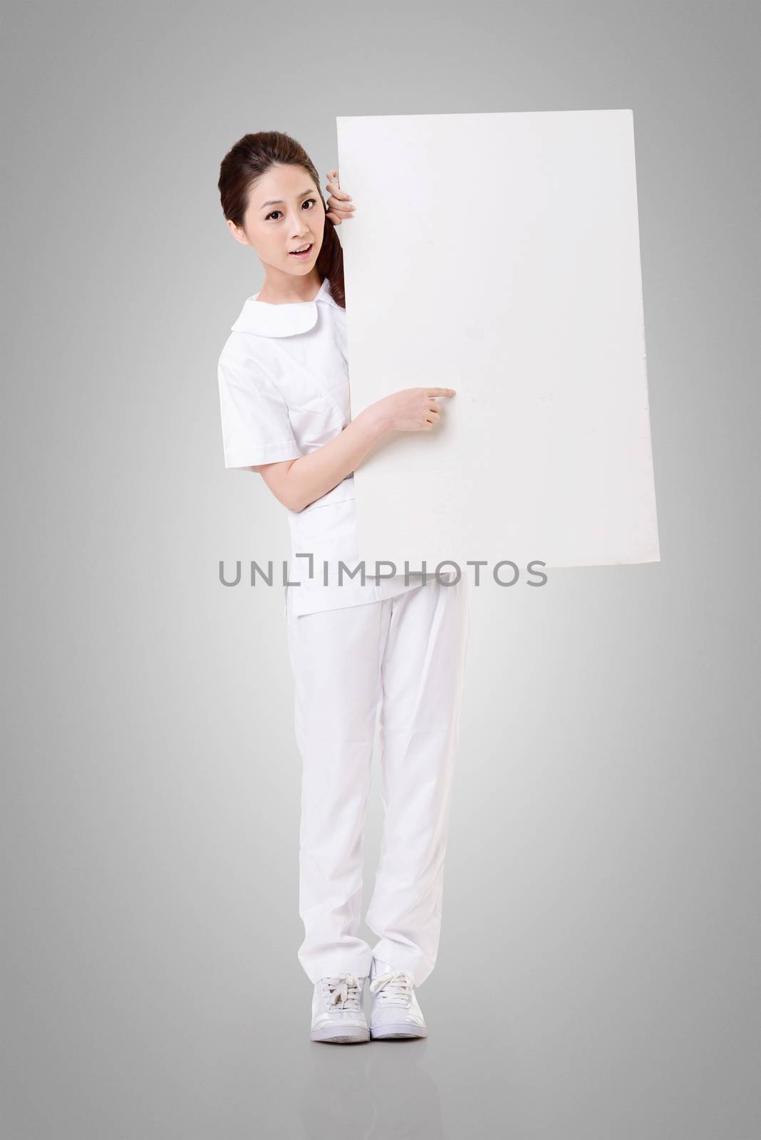 Smiling Asian nurse holding blank board, woman portrait isolated.
