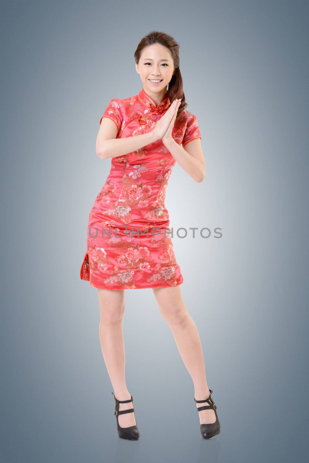 Smiling Chinese woman dress traditional cheongsam at New Year, studio shot isolated.