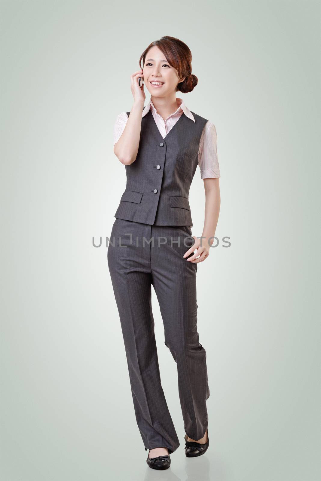 Young business woman talking on cellphone, full length portrait on with clipping path.