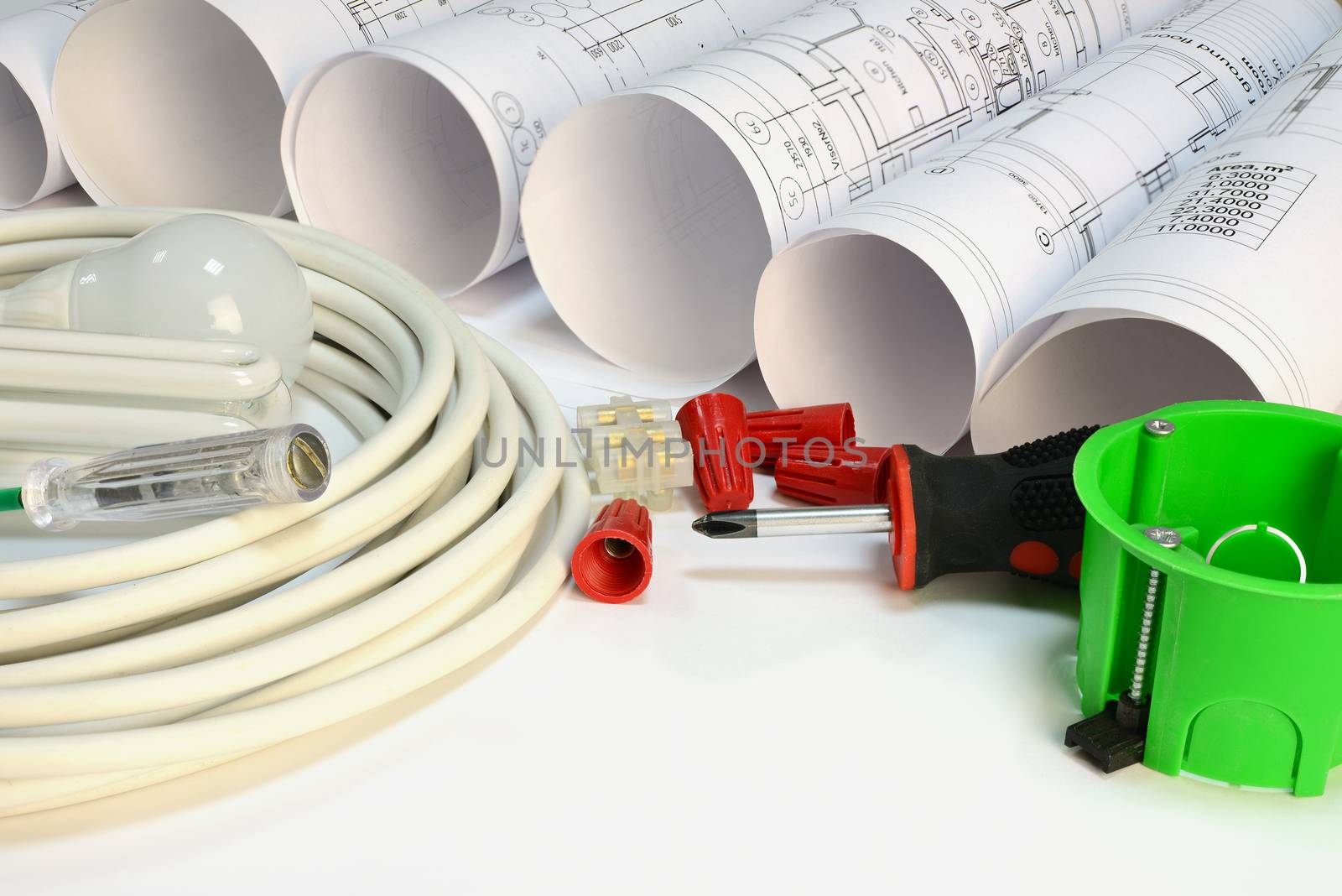 Drawing rolls, socket box, power cable, screwdriver, lamps, test pen, terminal block, wire connectors on white surface