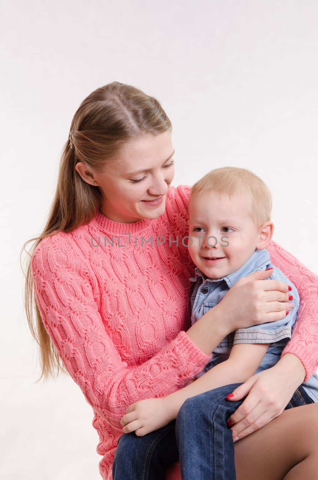On the lap of a young beautiful girl sits her three year old son