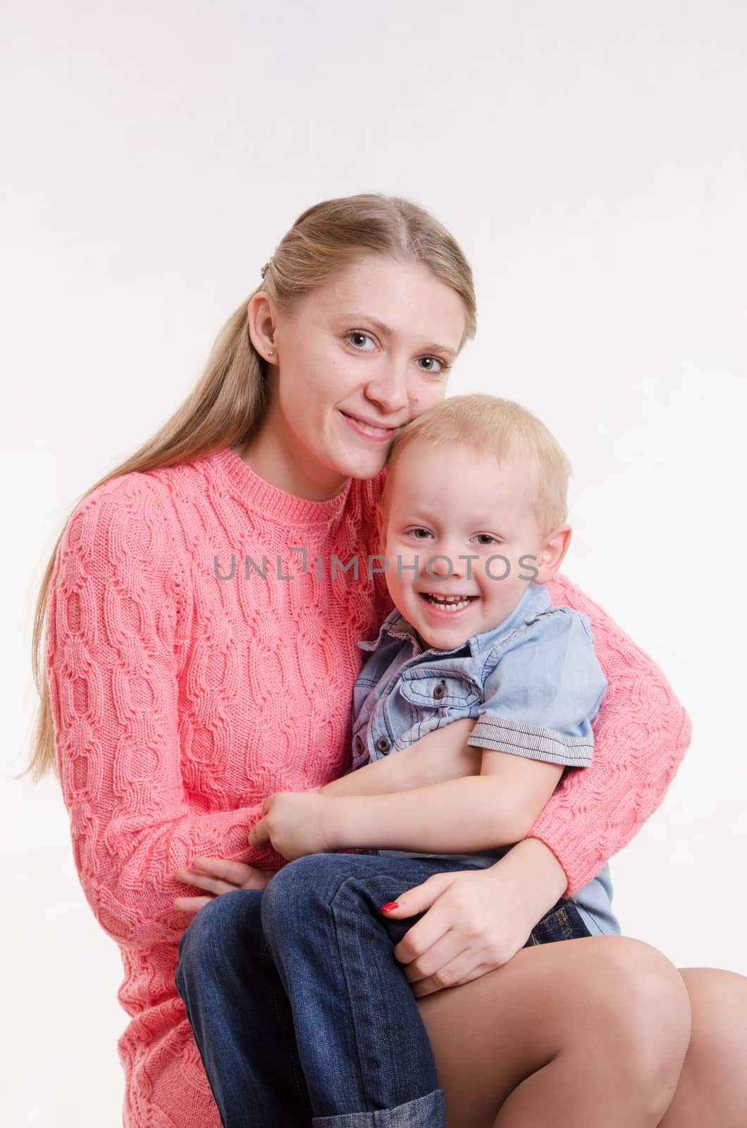 On the lap of a young beautiful girl sits her three year old son