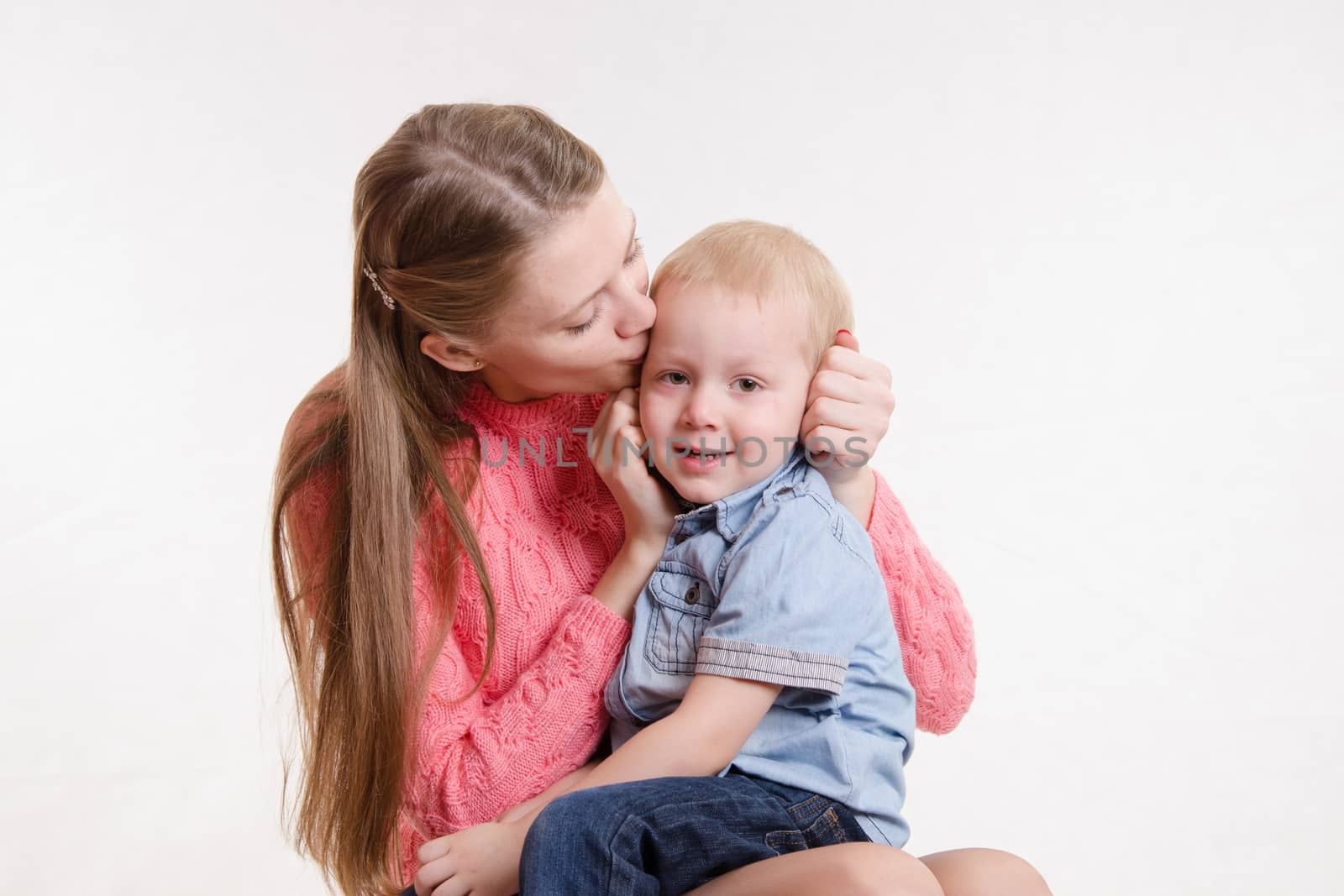 On the lap of a young beautiful girl sits her three year old son