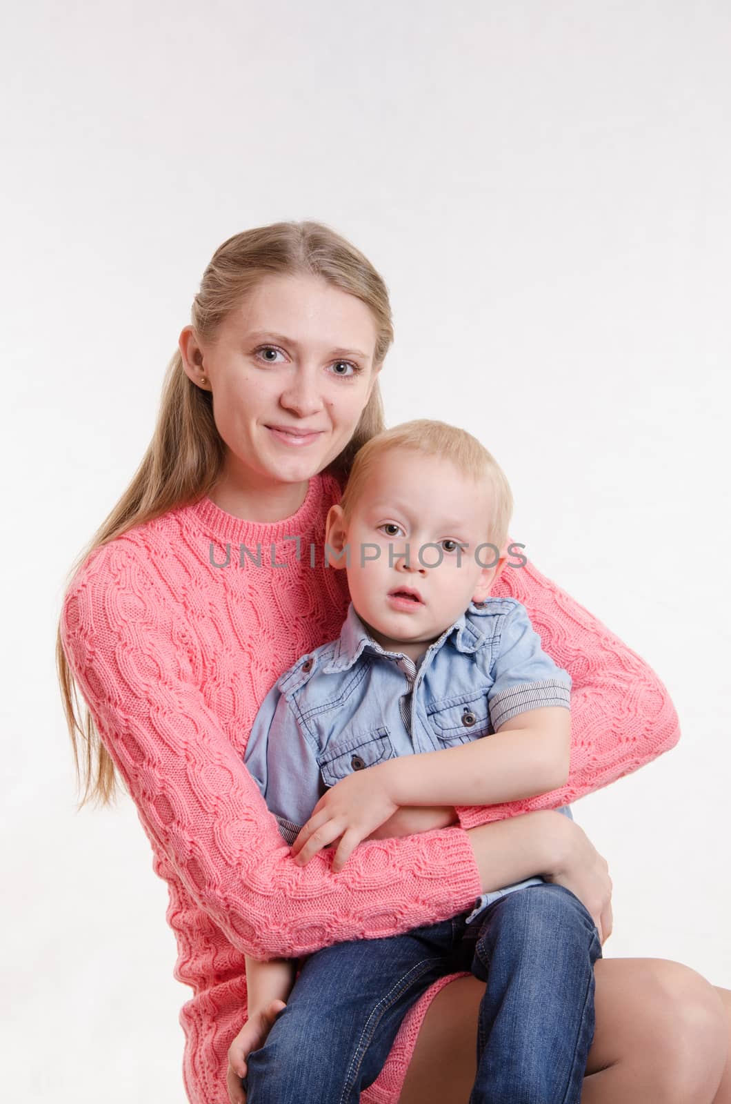 On the lap of a young beautiful girl sits her three year old son
