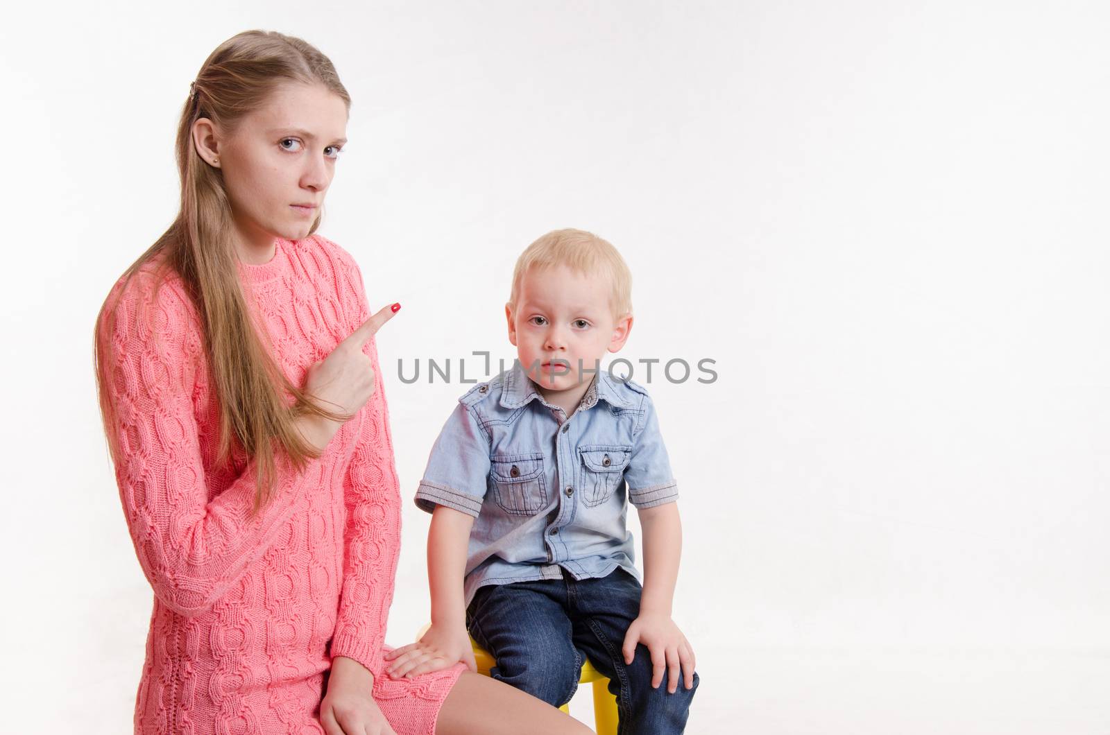 Young beautiful mother scolds her rebellious and moody three year old boy