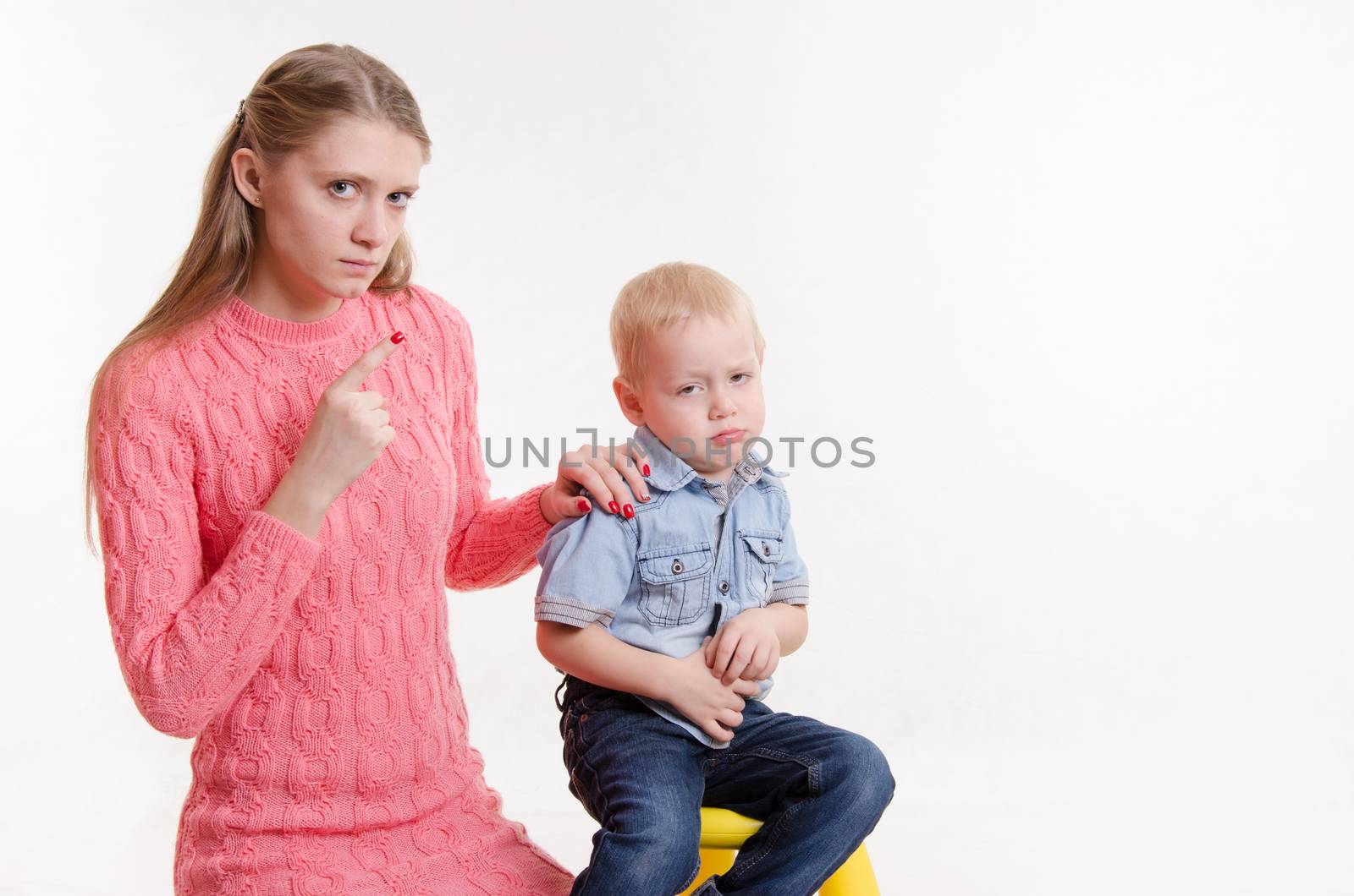 Young beautiful mother scolds her rebellious and moody three year old boy