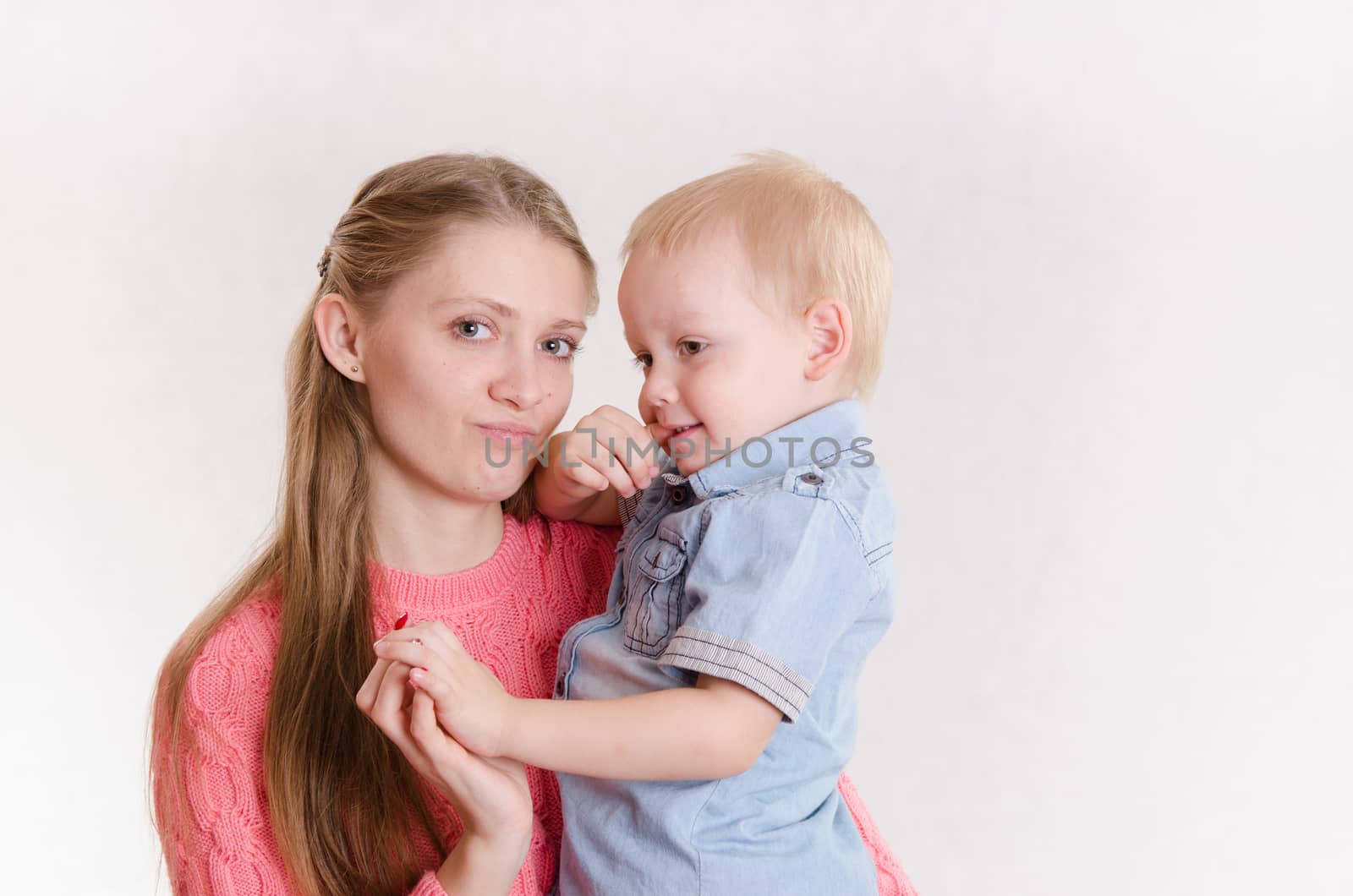 Young beautiful girl sitting on a chair with a three year old son