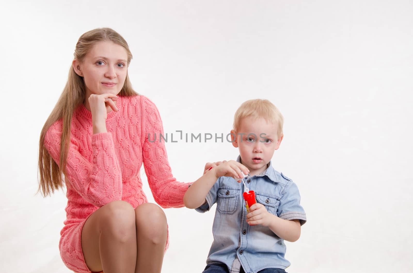 Young beautiful girl blow bubbles with a three year old son