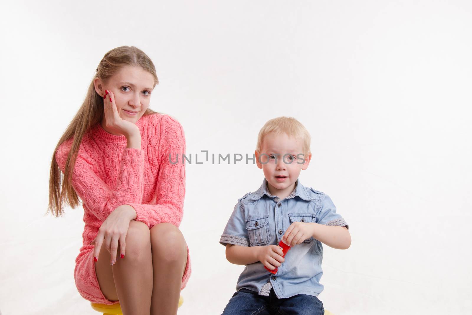 Young beautiful girl blow bubbles with a three year old son