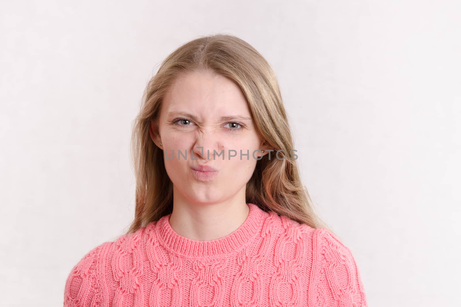 Portrait of a young emotional beautiful girl of the European appearance on a white background