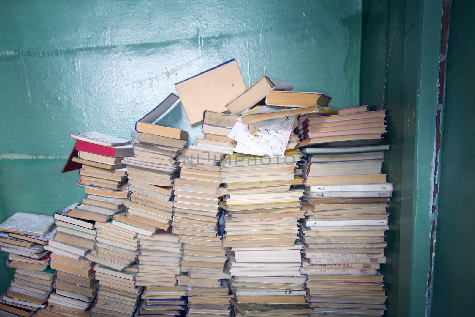 pile of books at a wall forgotten and left