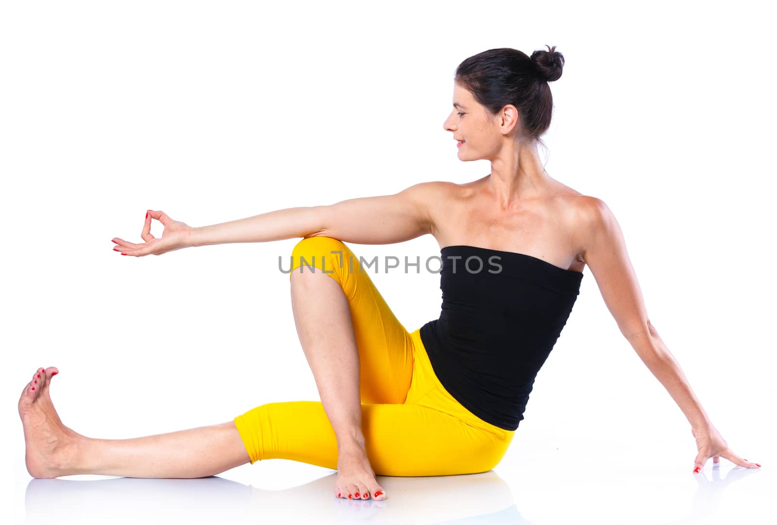 Yoga woman - pretty brunette in active wear doing yoga on white background