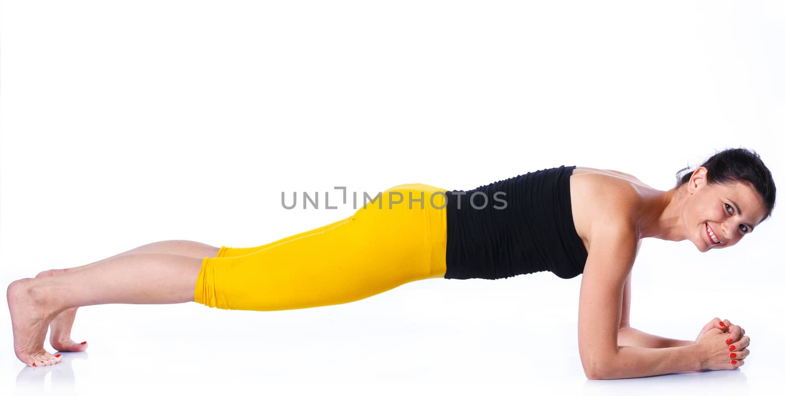 Yoga woman - pretty brunette in active wear doing yoga on white background