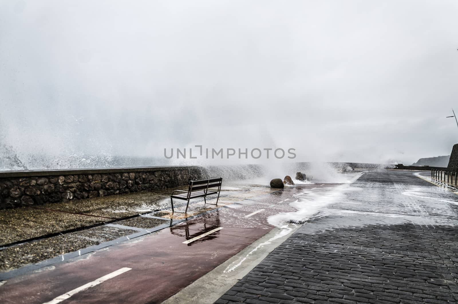 Beautiful shot of a splashing wave in Getaria city, right before the storm.