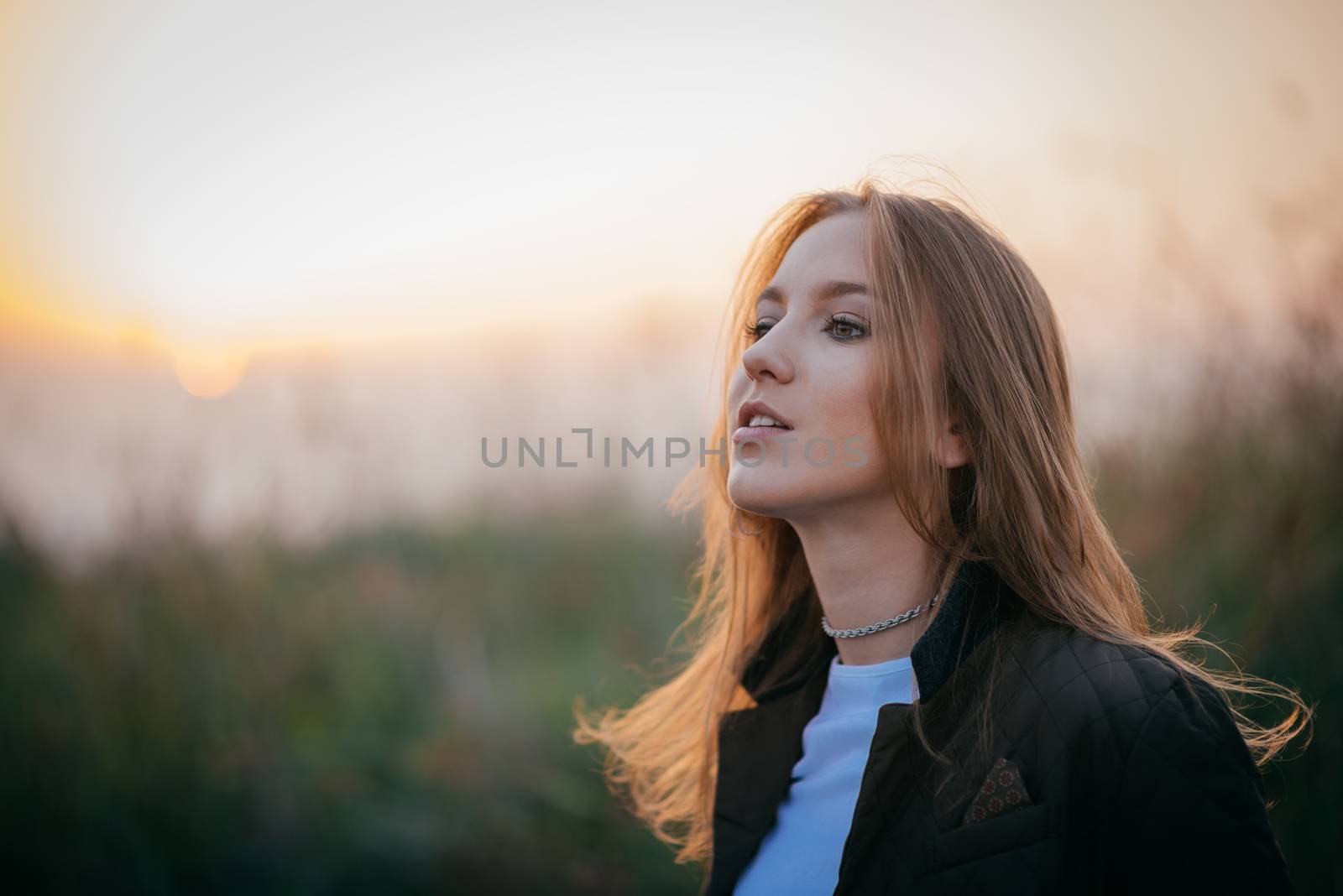 Young brunette girl in late autumn walking outdoors on sunset