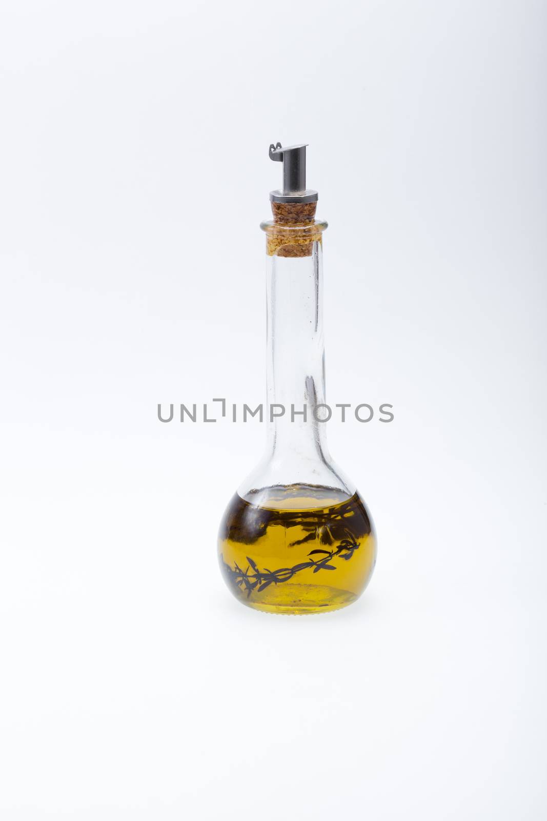 Thyme infused olive oil over white background 