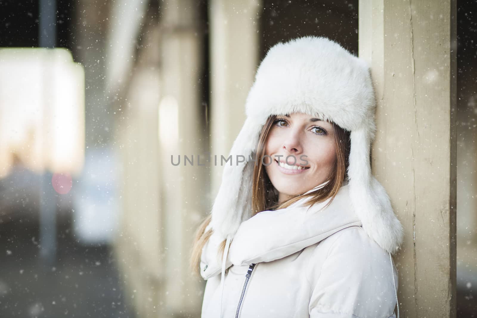 Girl in white hat and warm jacket in winter cold