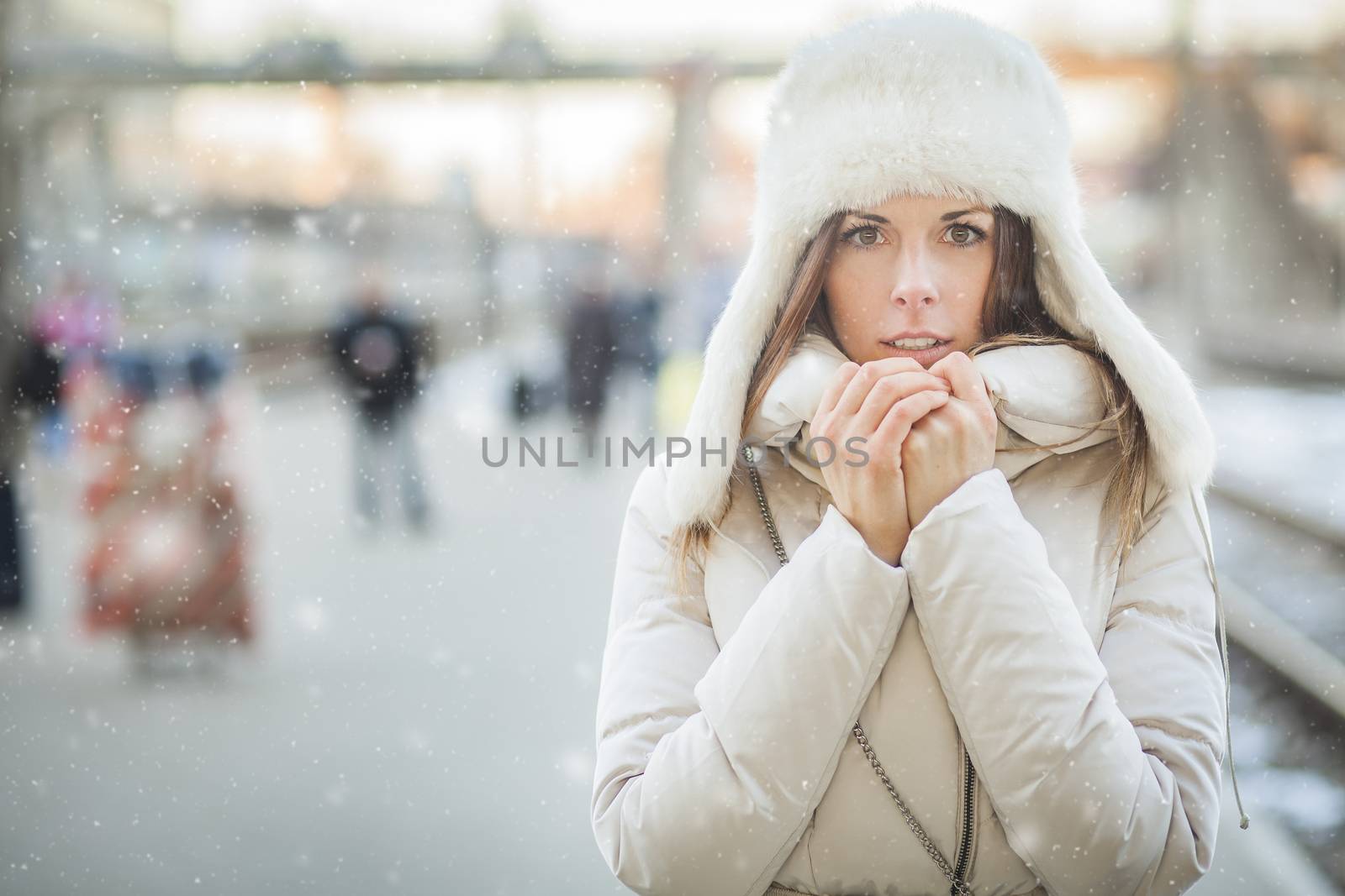 Girl freezing on a railroad platform in falling snow