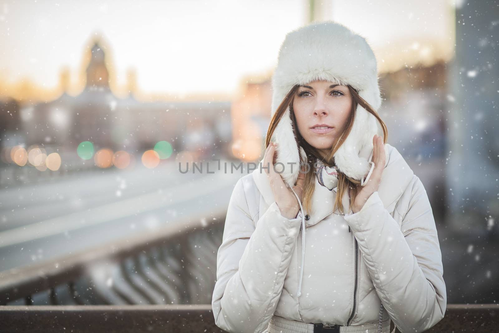 Brunette girl in cold weather with falling snow in russia