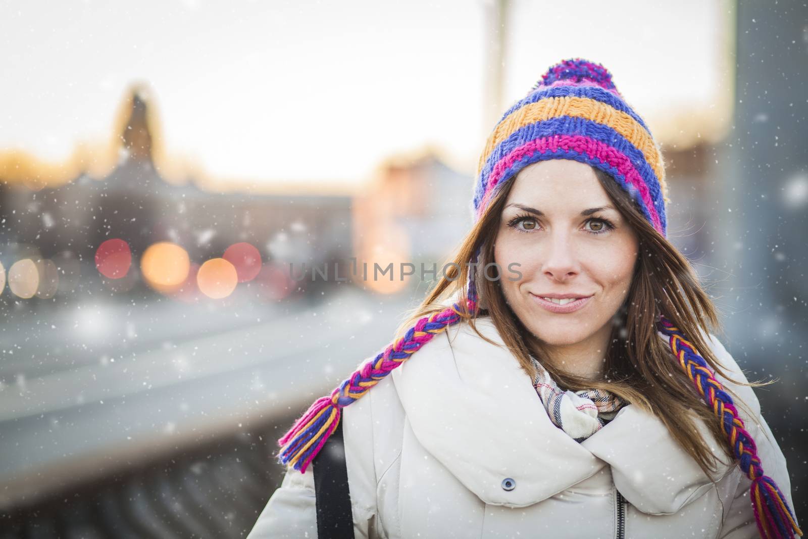 Positive girl with colorfull hat in winter city by Kor