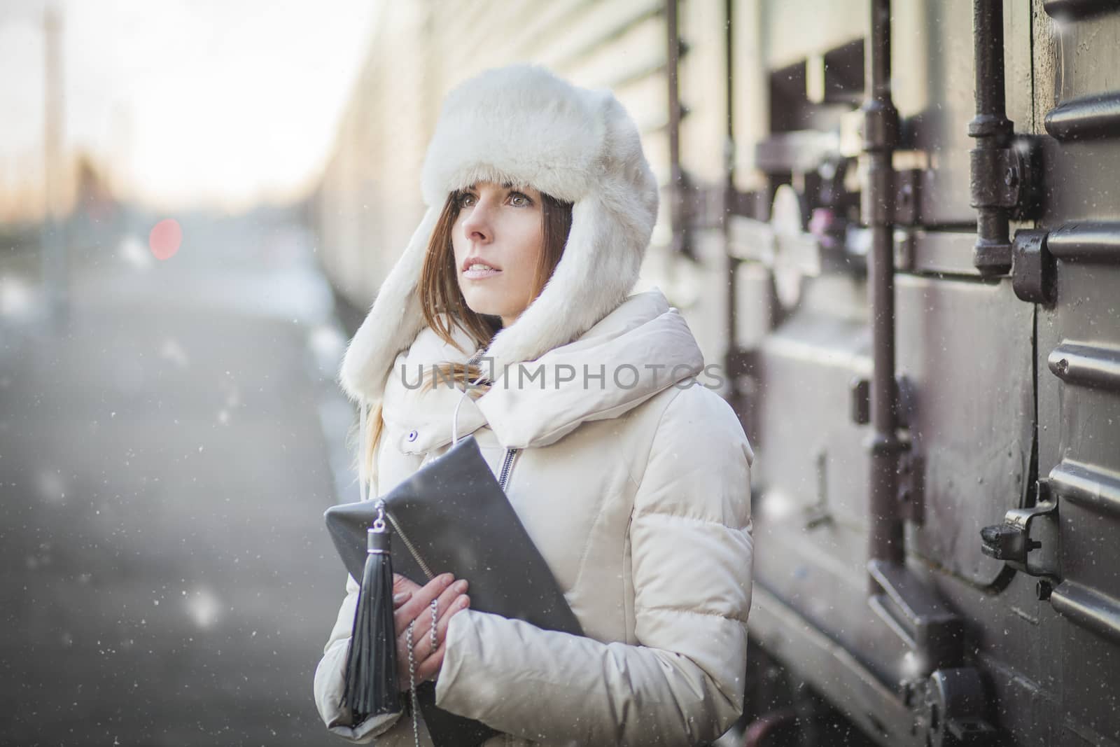 Pretty girl in winter blizzard on railroad station by Kor