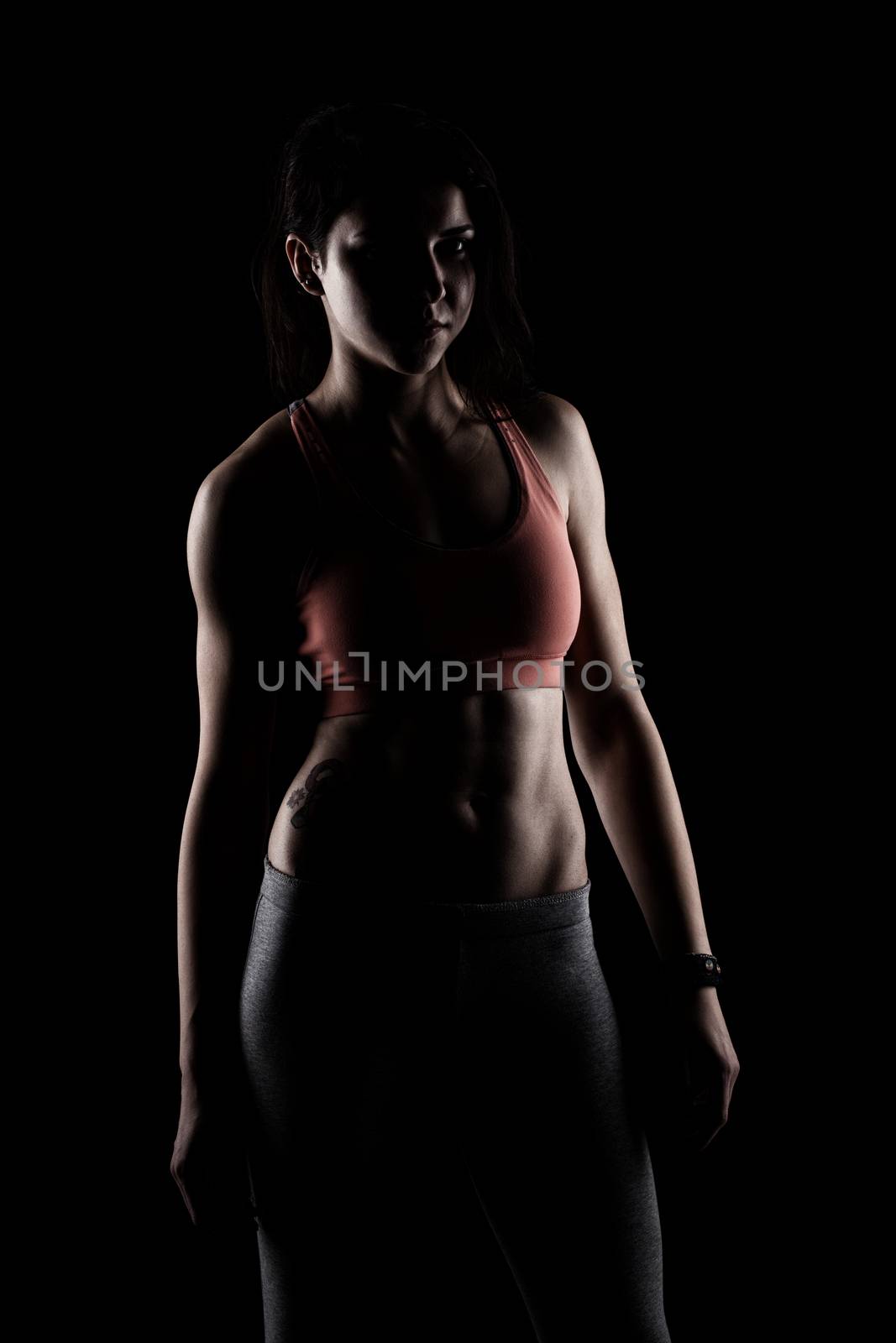 fitness girl posing against dark background