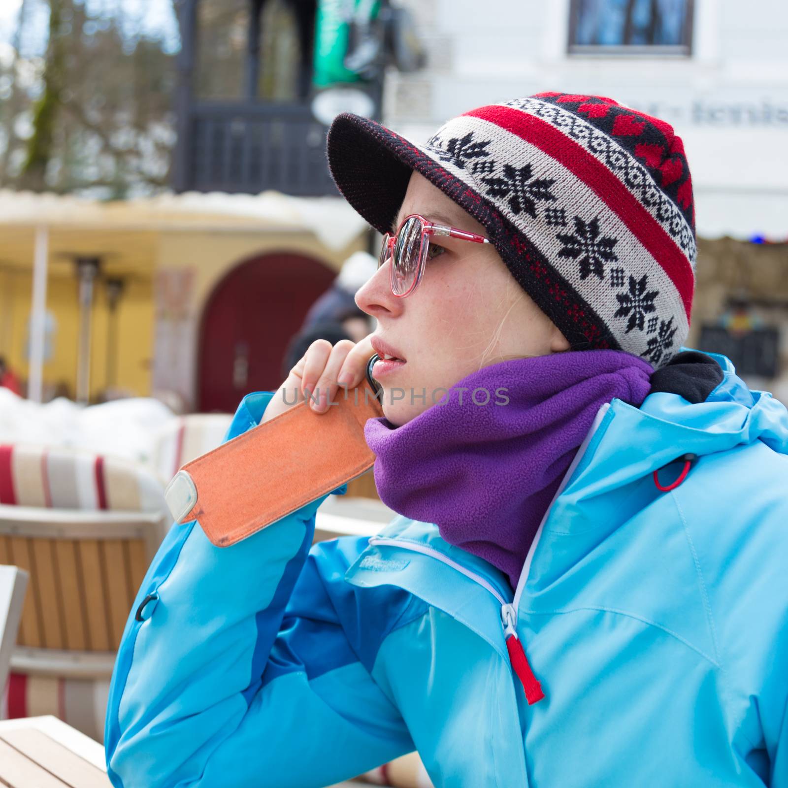 Woman in ski resort using smartphone. by kasto