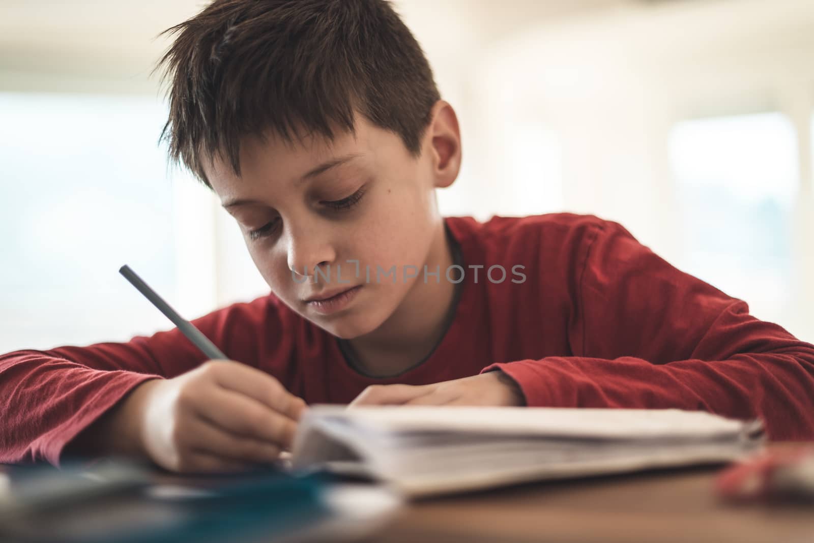 Boy doing homework at home, close up shot