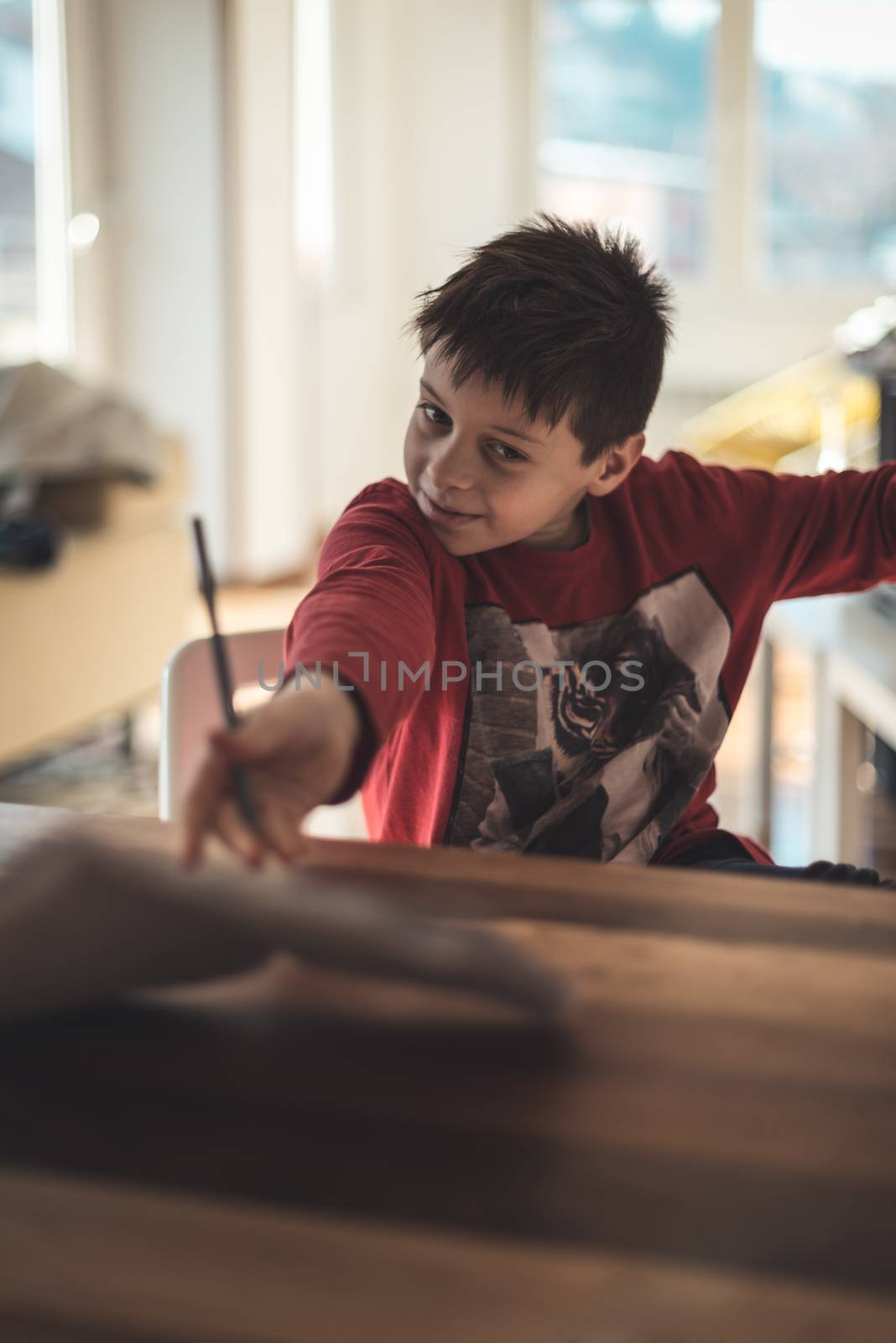 Boy cheering that the homework is finished by throwing the notebook