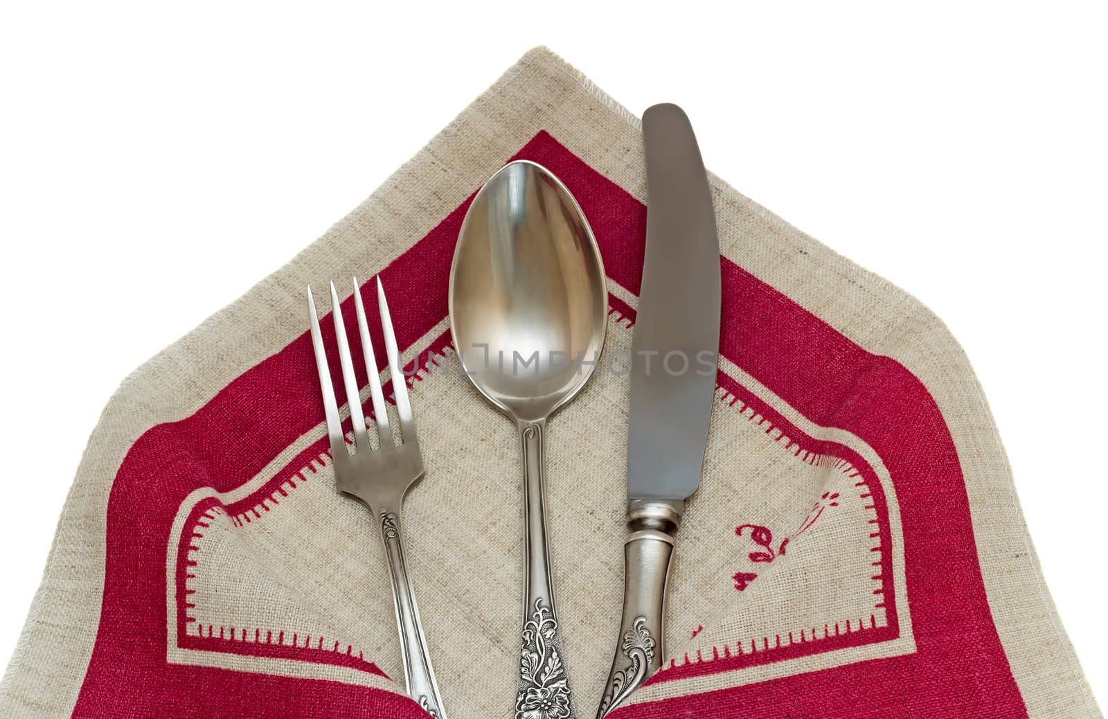 On the linen cloth lying knife, fork, spoon. Presented on a white background.