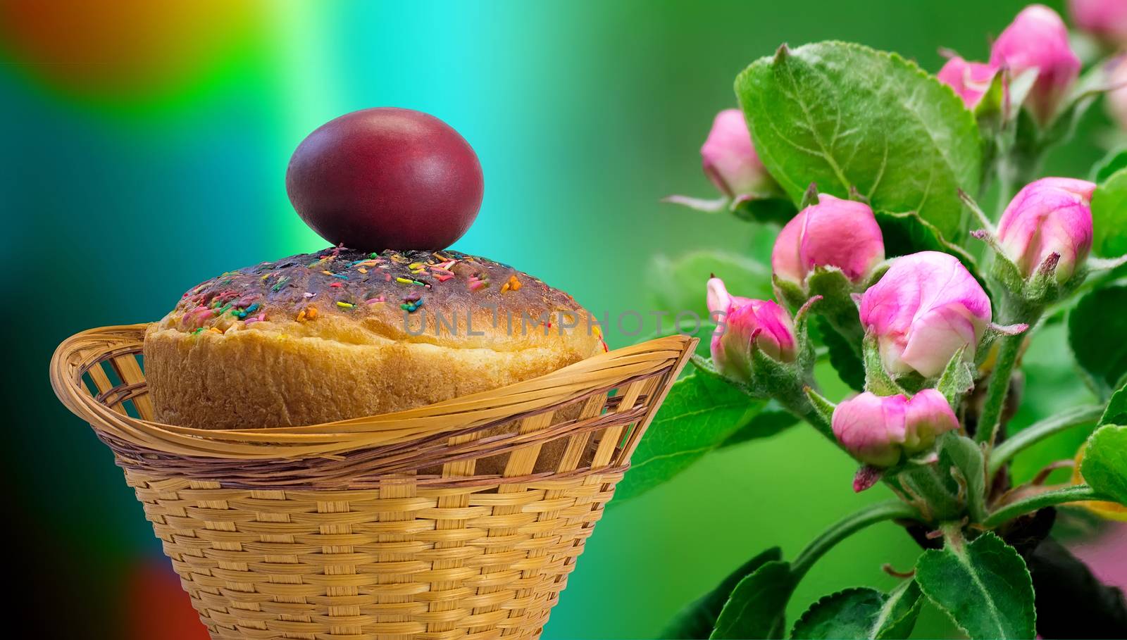 In a wicker basket next to the branch of Apple blossoms are Easter cake and red Easter egg .