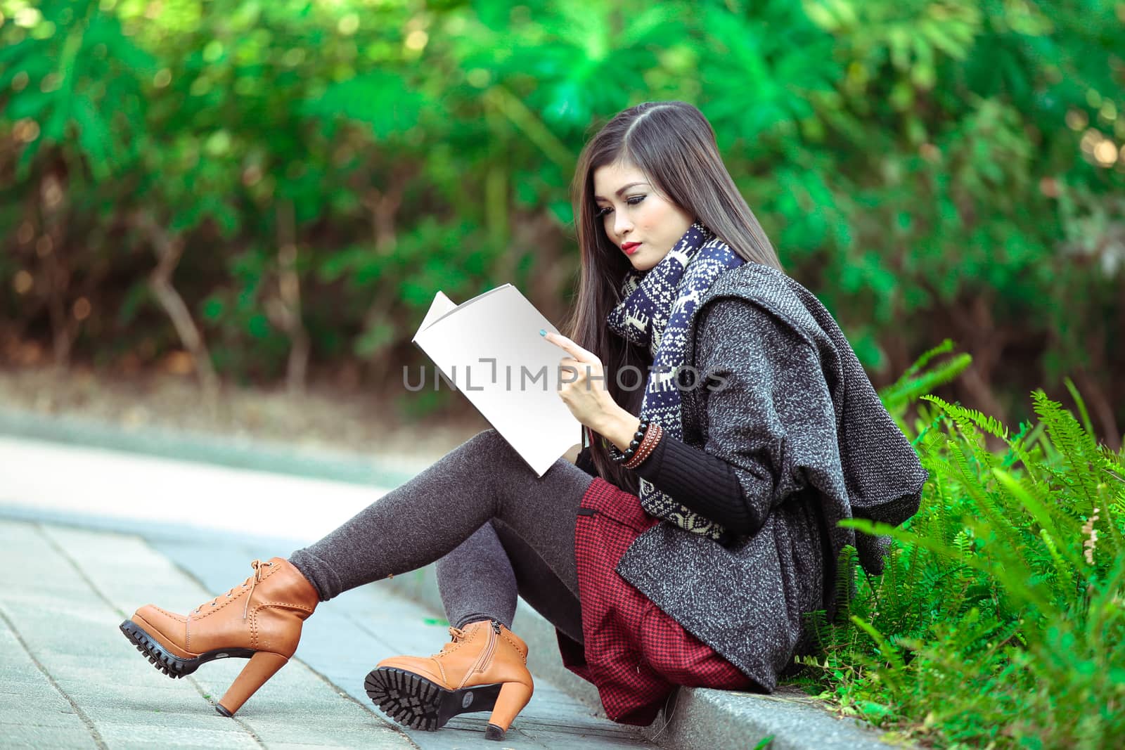 Beautiful young woman with a magazine