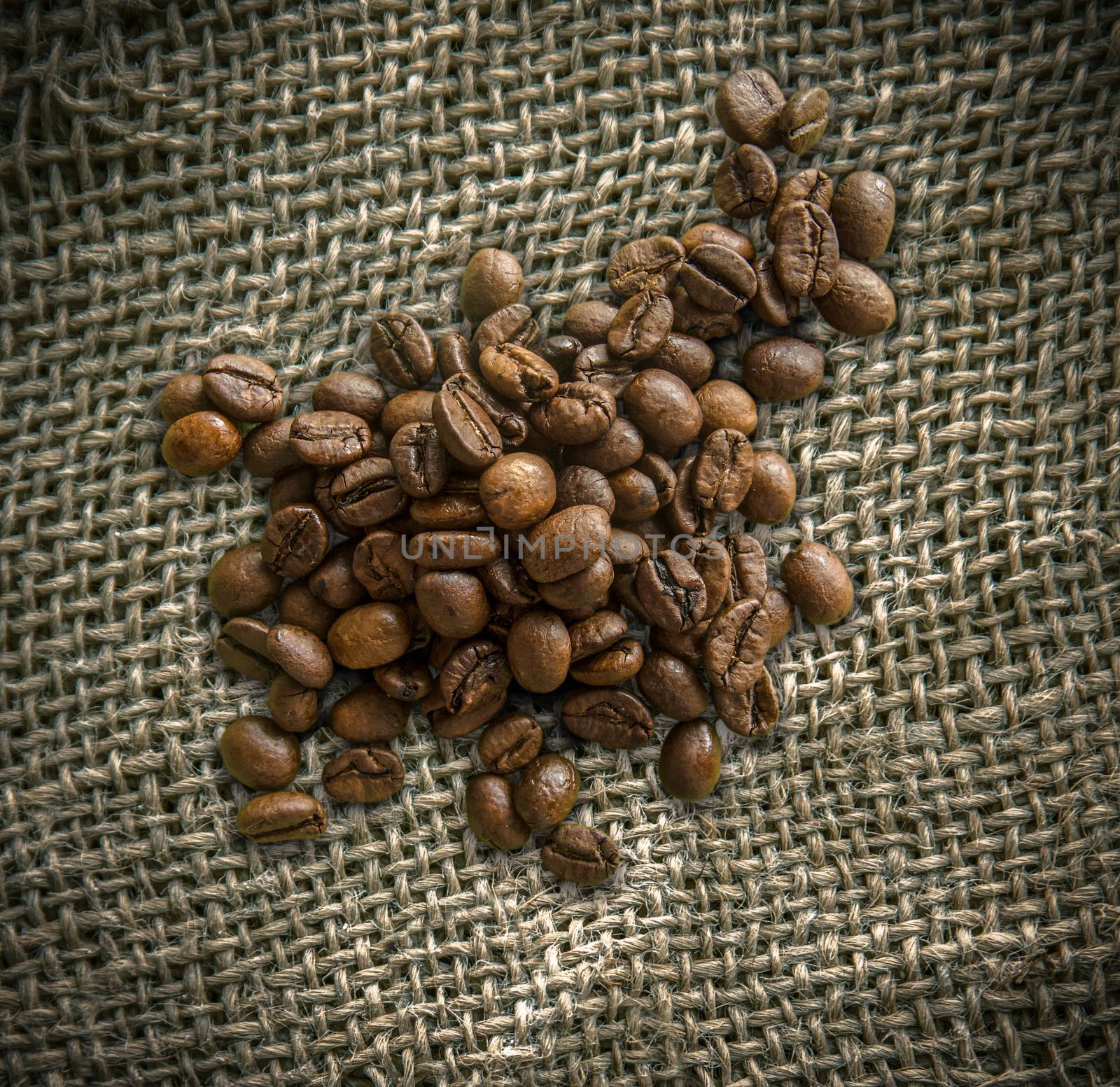 Organic Fair Trade Coffee Beans On Top Of A Rustic Woven Burlap Bag