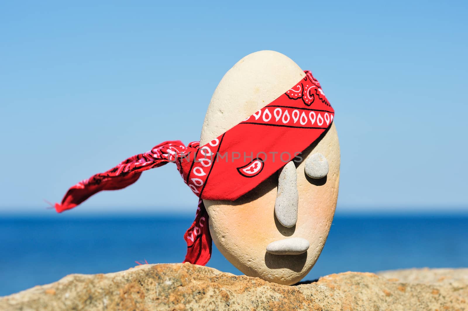 Image of stone head with a patterned red bandana