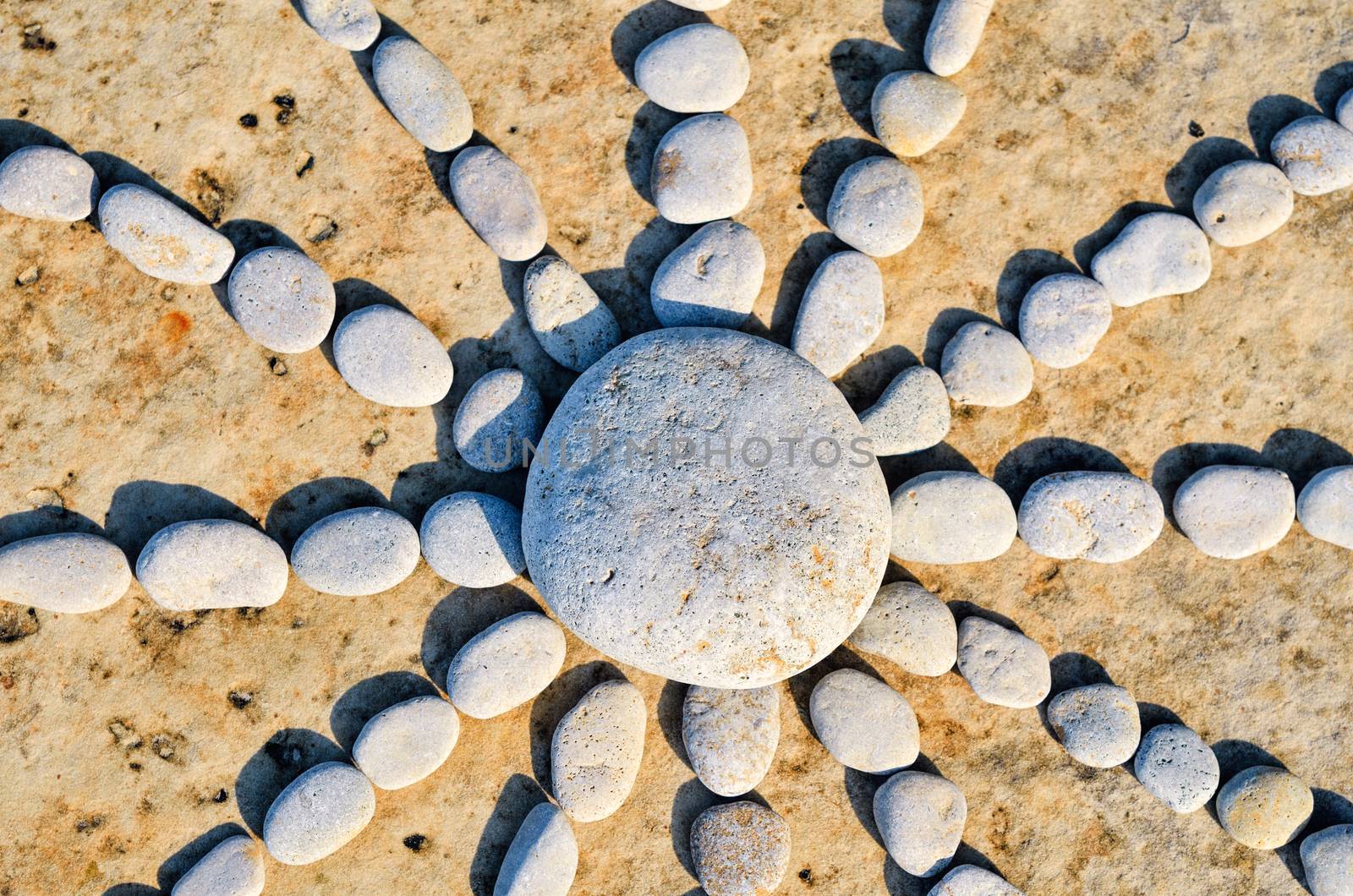 Sun rays from pebbles on the sandy beach
