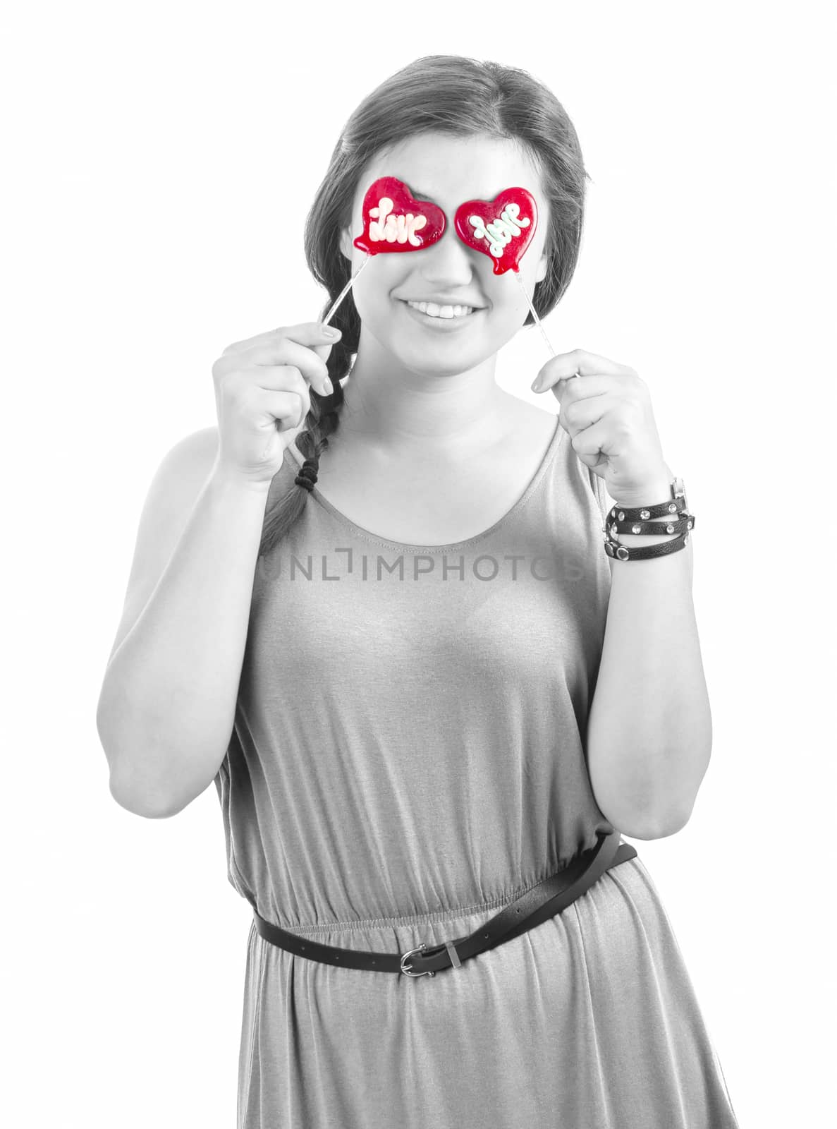 smiling teenager girl with heart shaped lollipop on white background