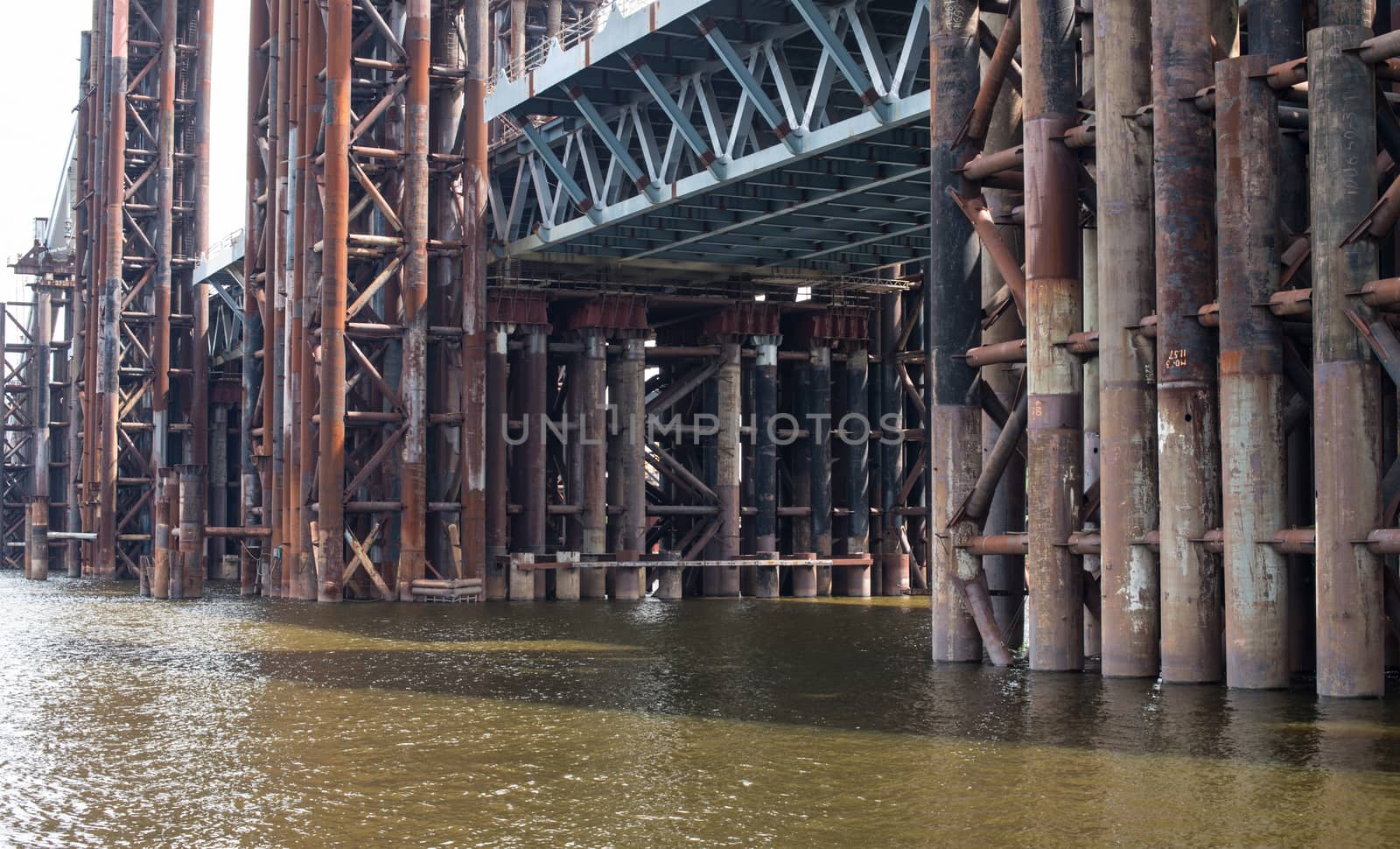 Bridge construction. Rusty metal piers of the unfinished bridge across the Dnieper in Kyiv (Ukraine).