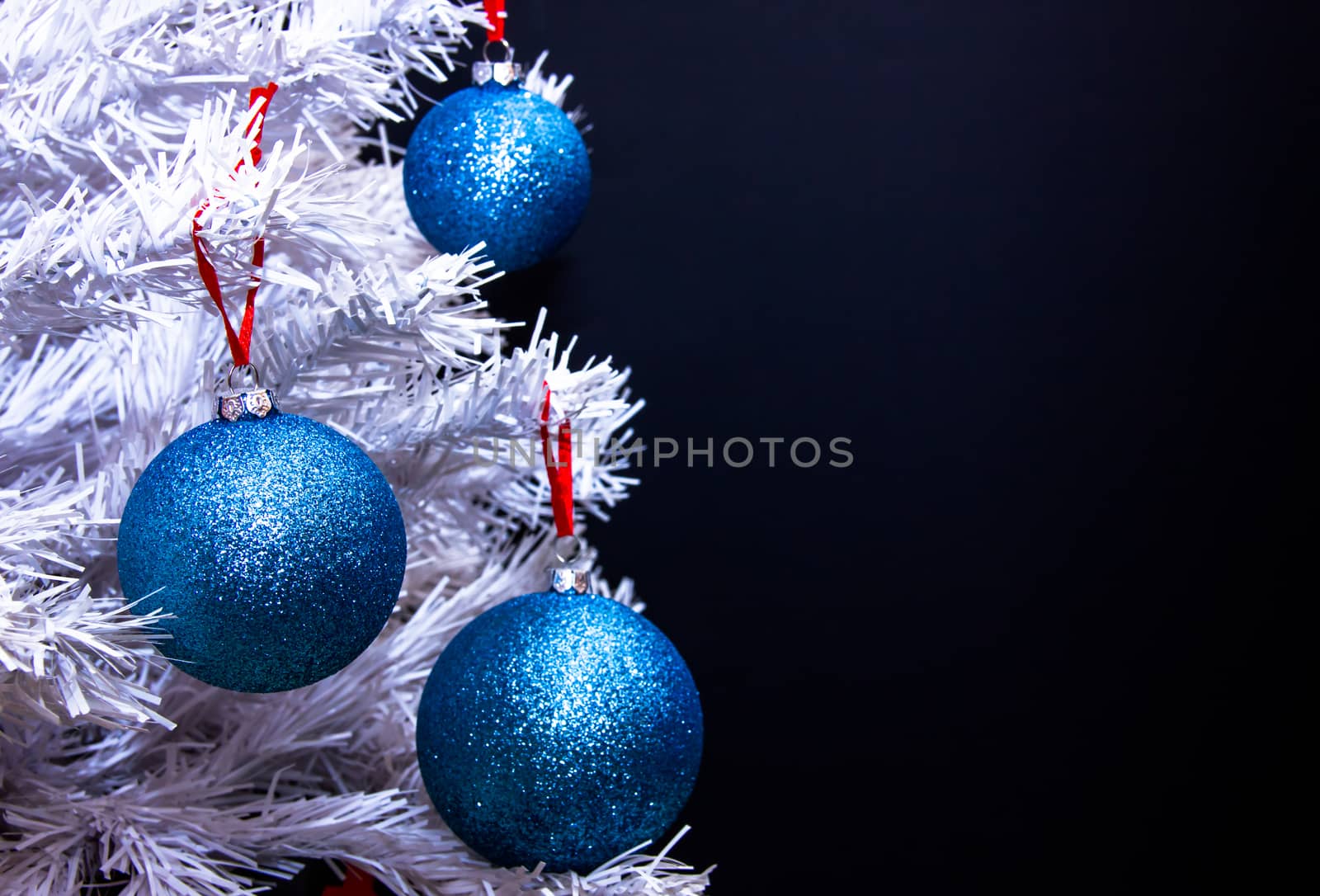 Christmas balls on tree with white branches to close