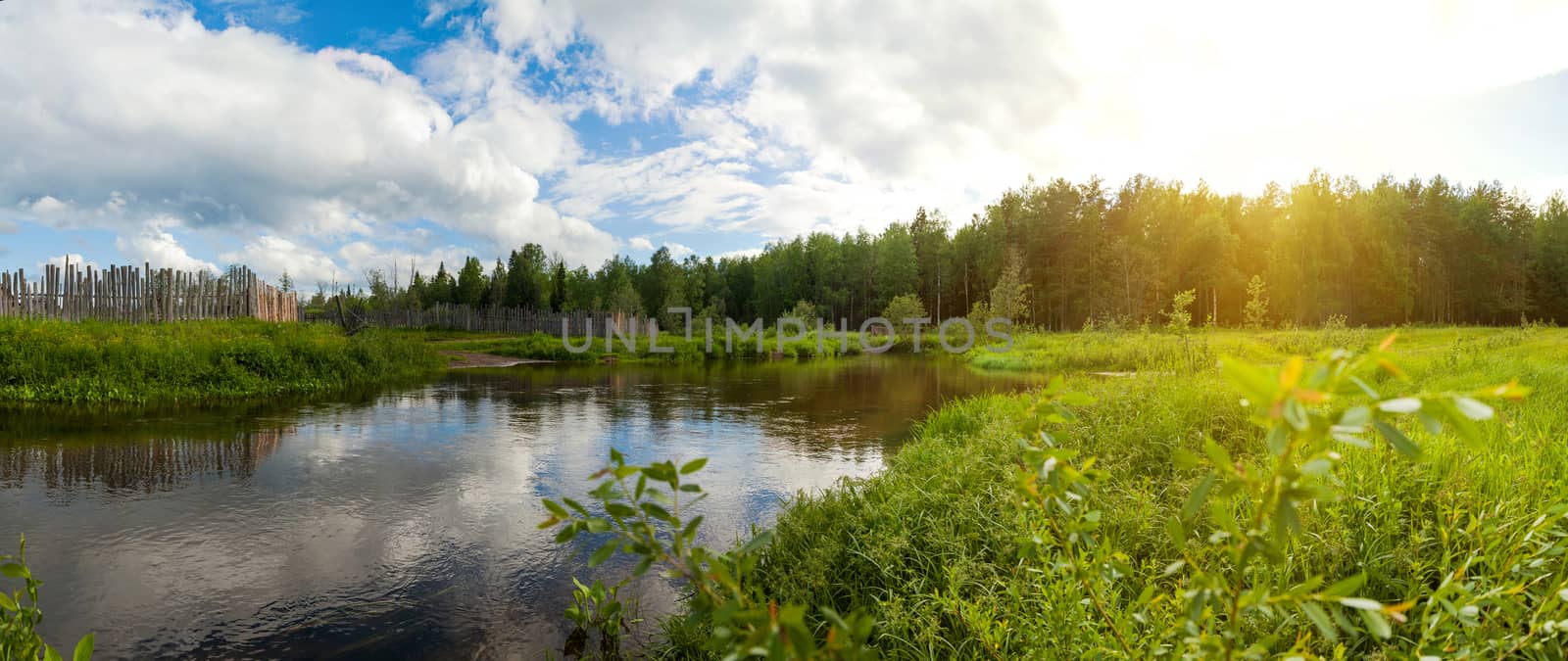 a small river that flows near the village, next to the field and forest