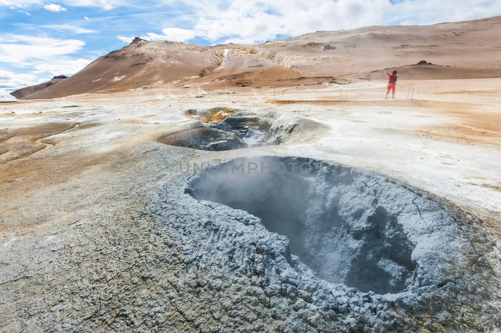 Mudpot in the geothermal area Hverir, Iceland. The area around the boiling mud is multicolored and cracked. HDR image