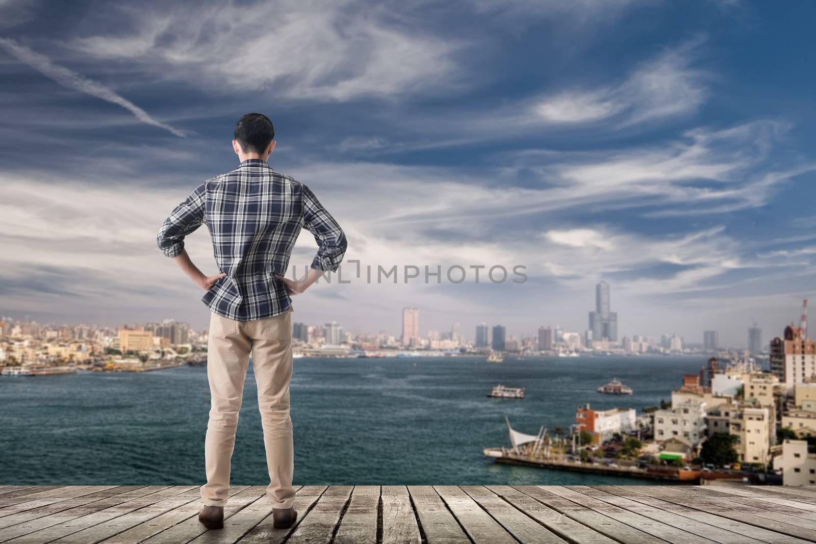 Asian man standing and looking the skyline of the city, Kaohsiung, Taiwan, Asia.