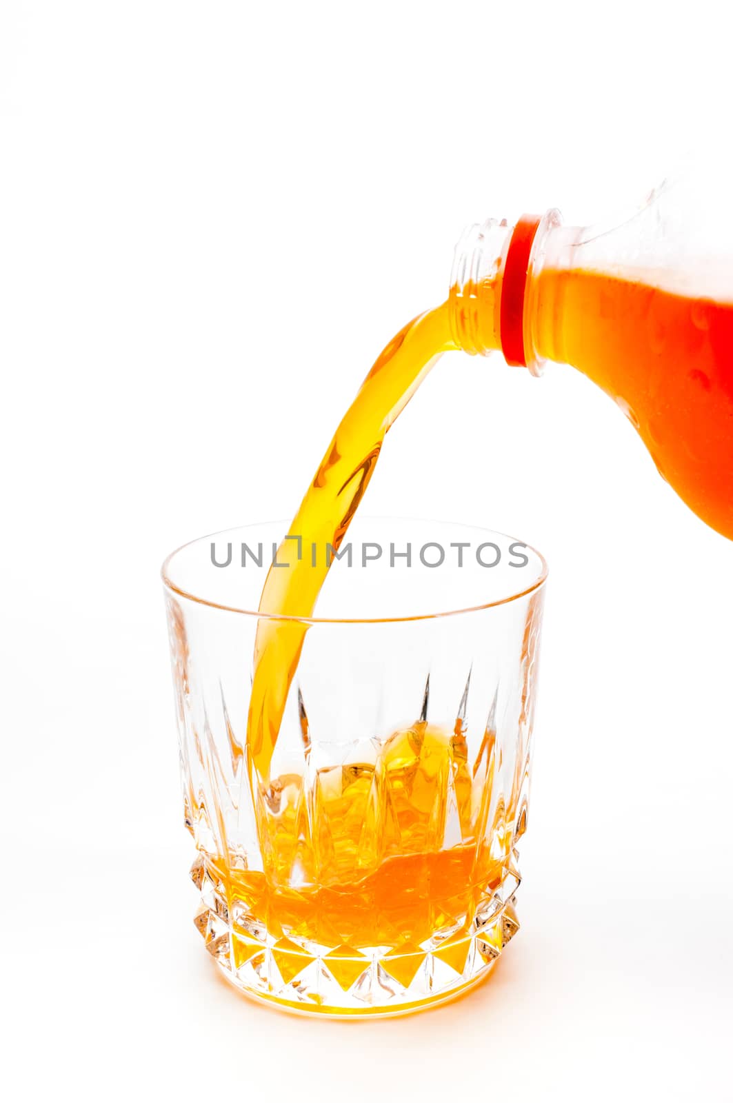 Pouring orange juice into the glass isolated on white